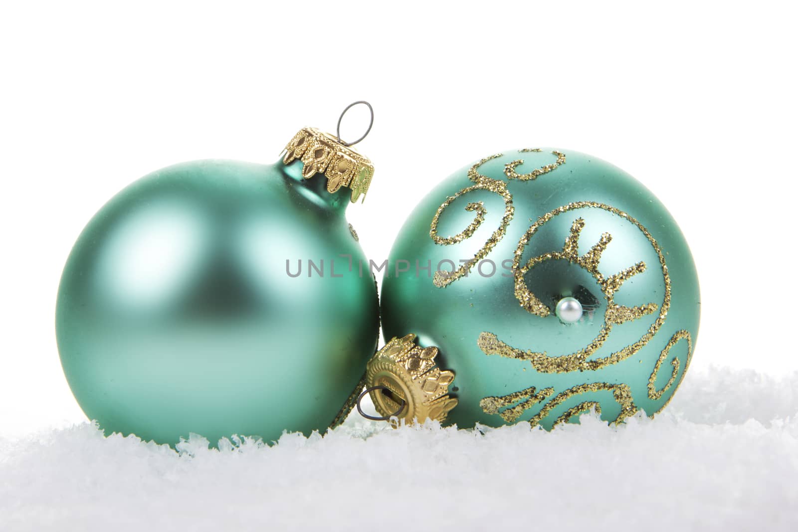 Christmas balls green, turquoise on snow on white background 