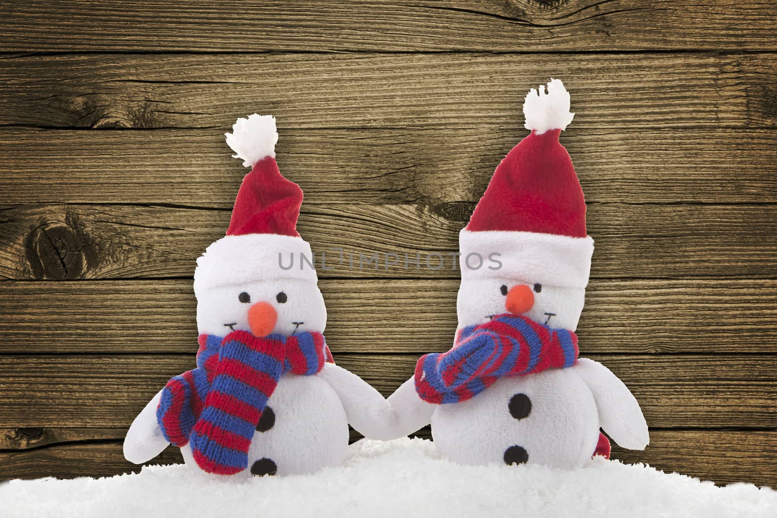 snow man (toy) on a wood background 