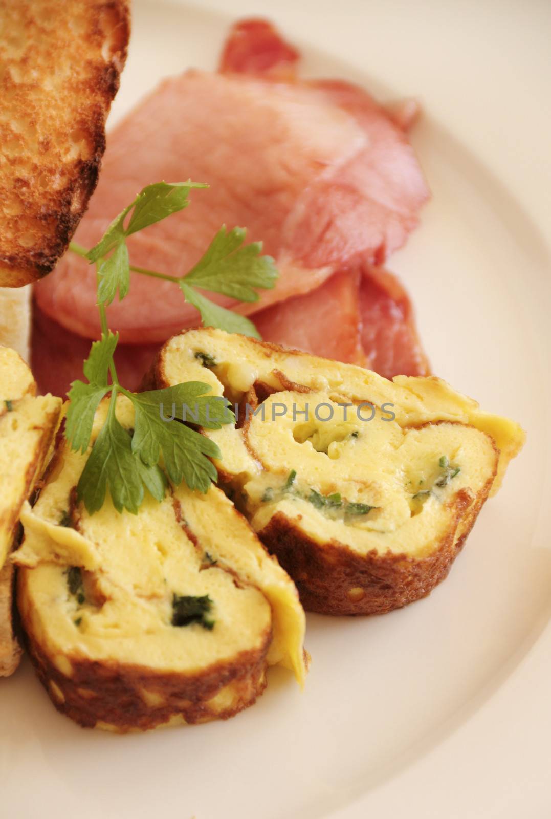 Delicious sliced rolled omelette with bacon and Turkish bread with parsley.