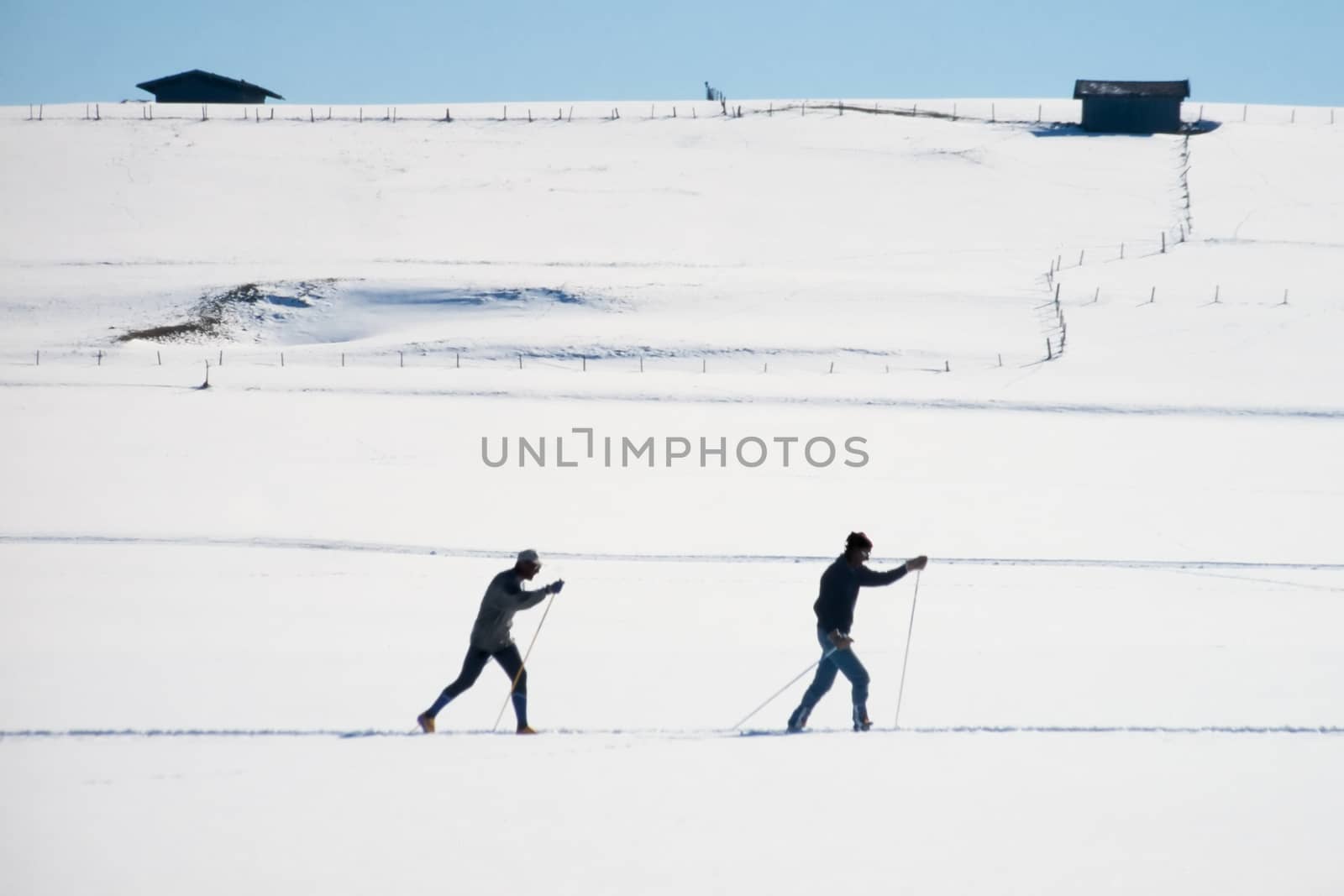 Cross country skiers skiing open expanse of snow by PiLens