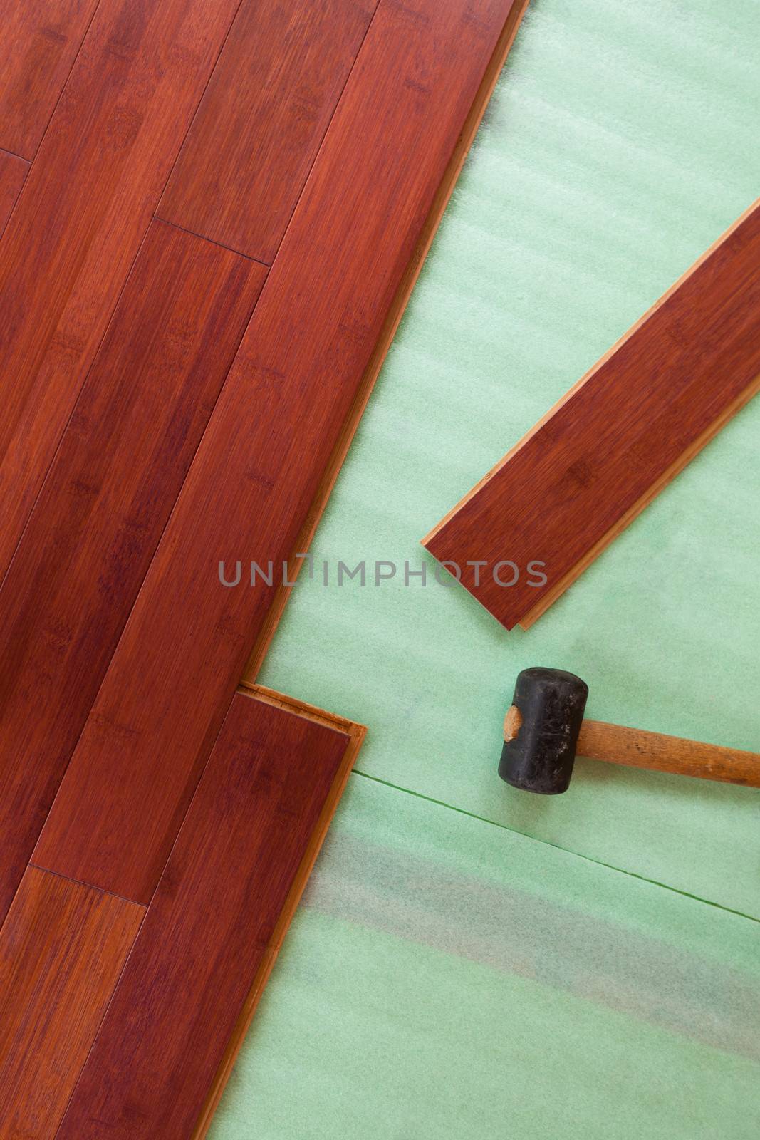 Wooden bamboo hardwood flooring planks being layed by PiLens