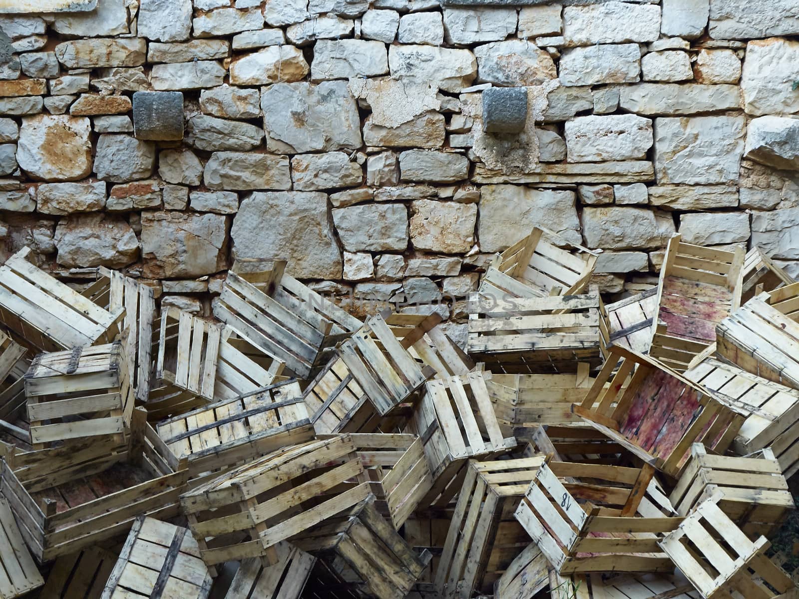 empty wooden boxes of grapes thrown to stone wall