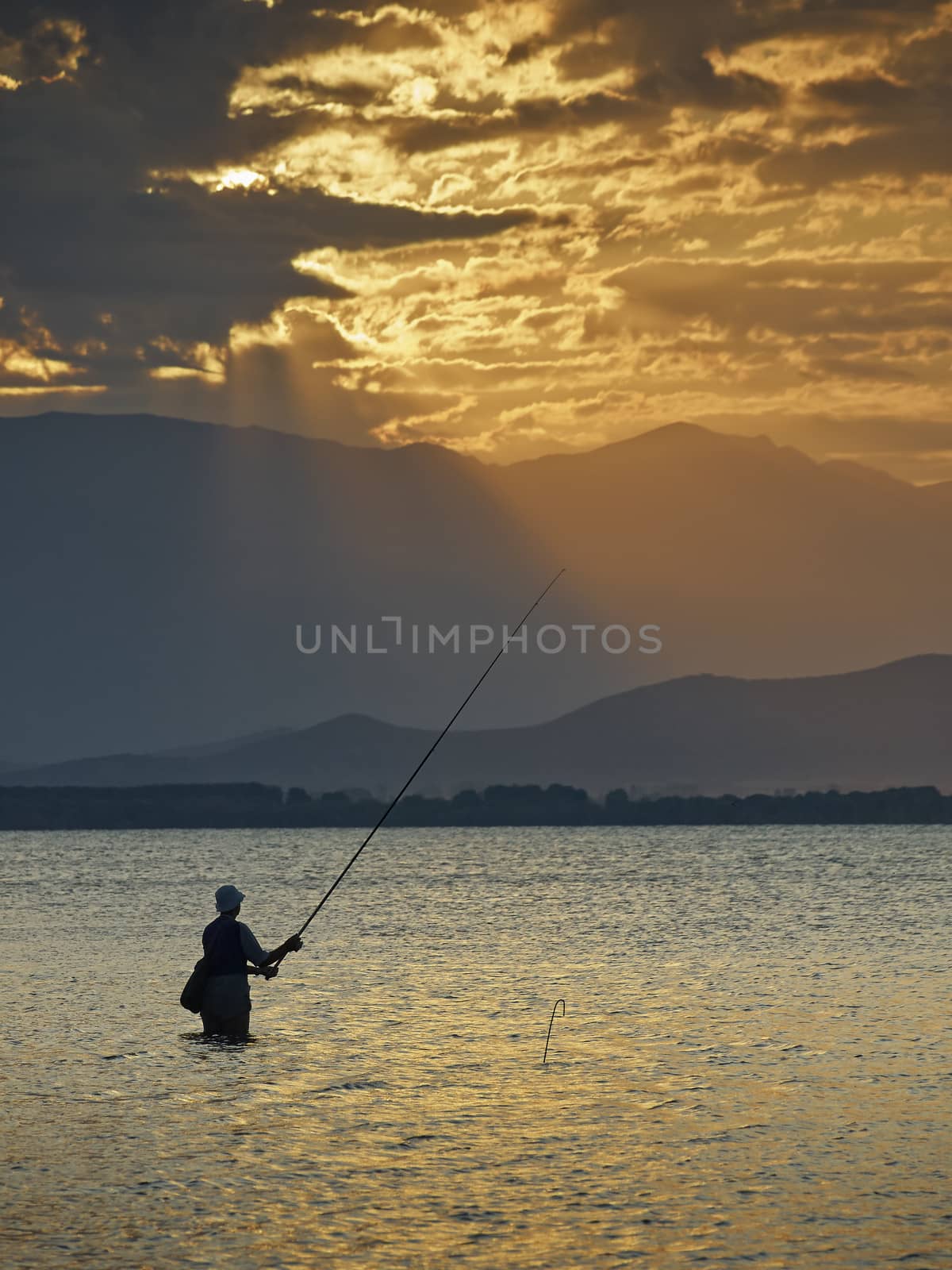 Fisherman at sunrise in Dojran lake     