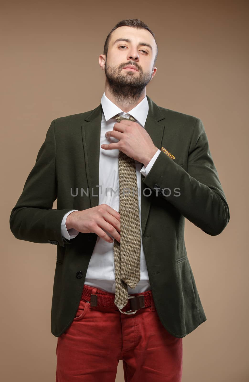 young man in a green suit and tie, beige background