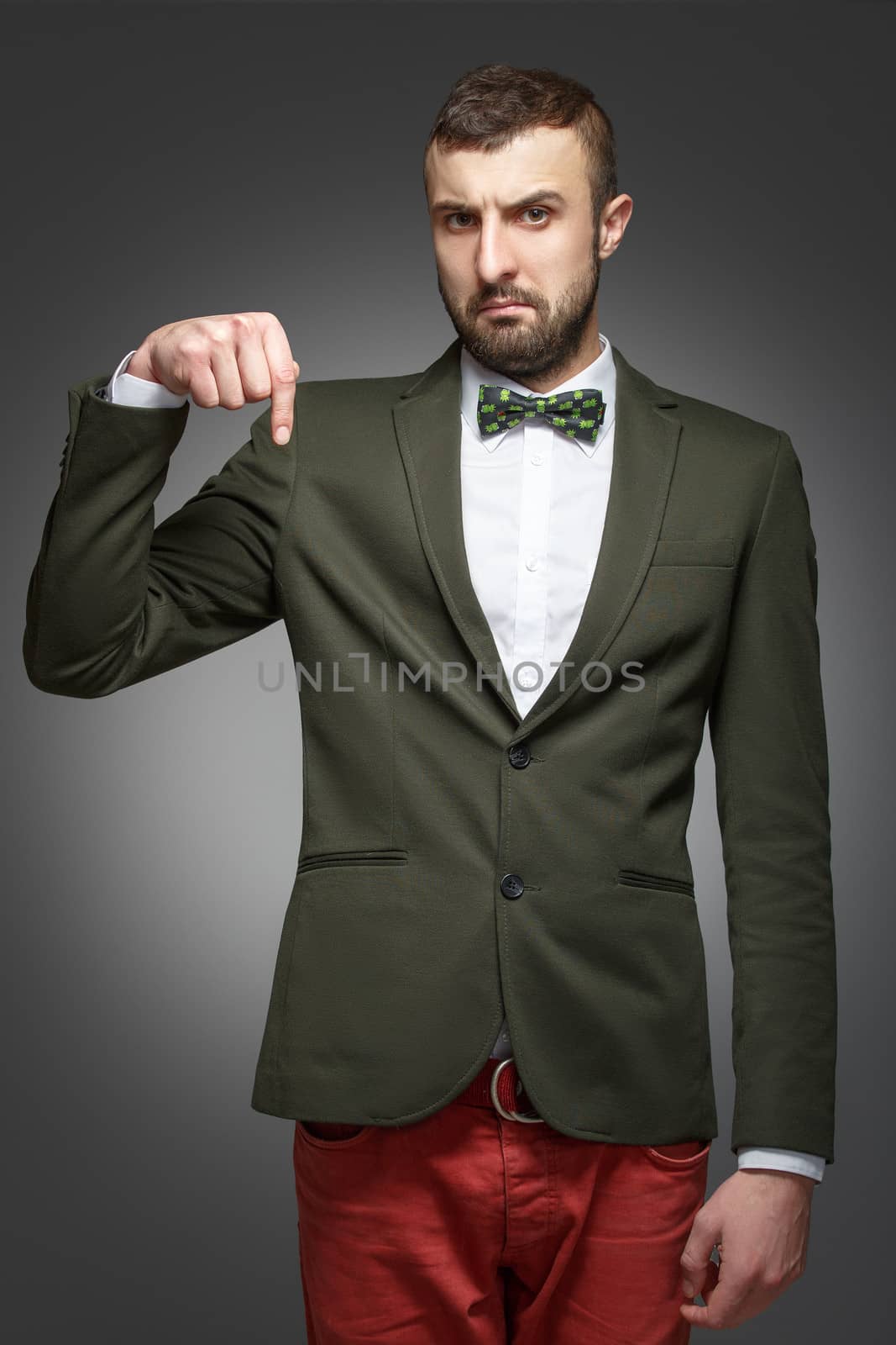young man in a green suit, pointing down