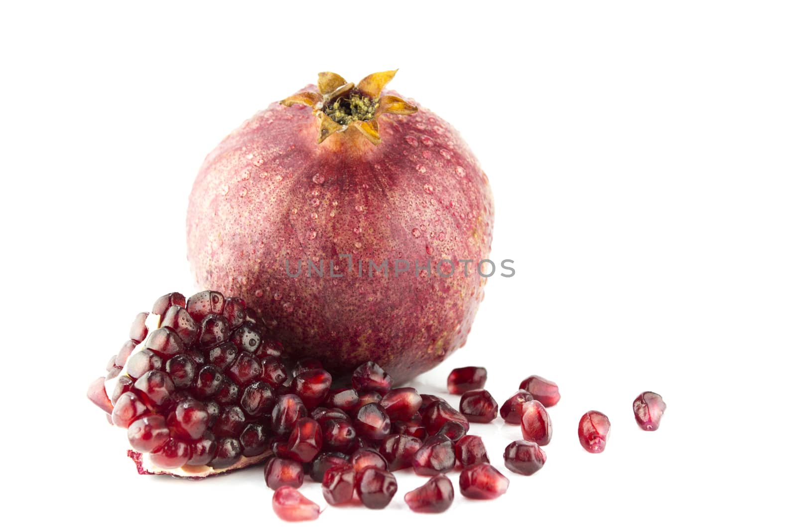 Ripe pomegranate fruit and part isolated on white background .