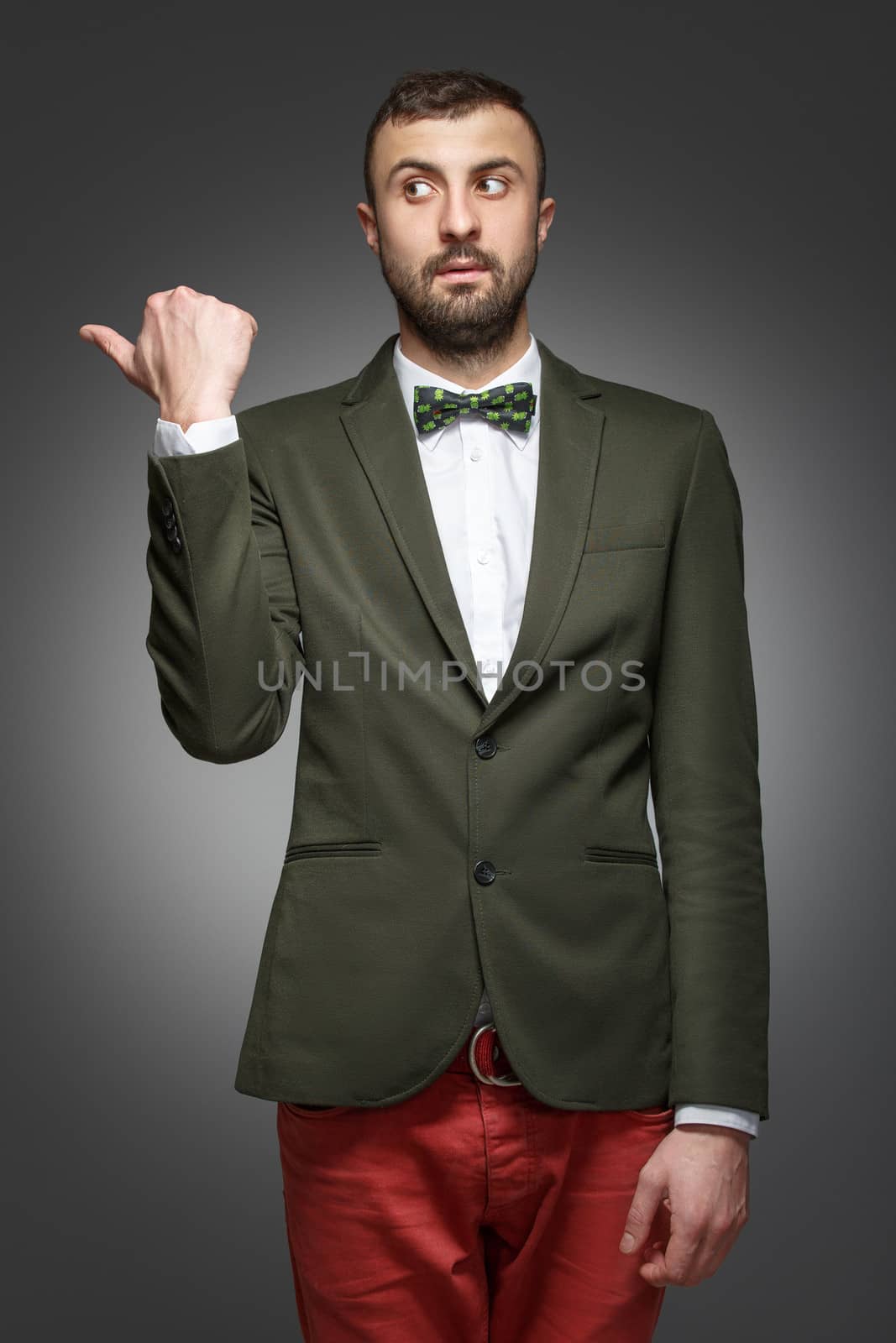 young man in a green suit, shows left