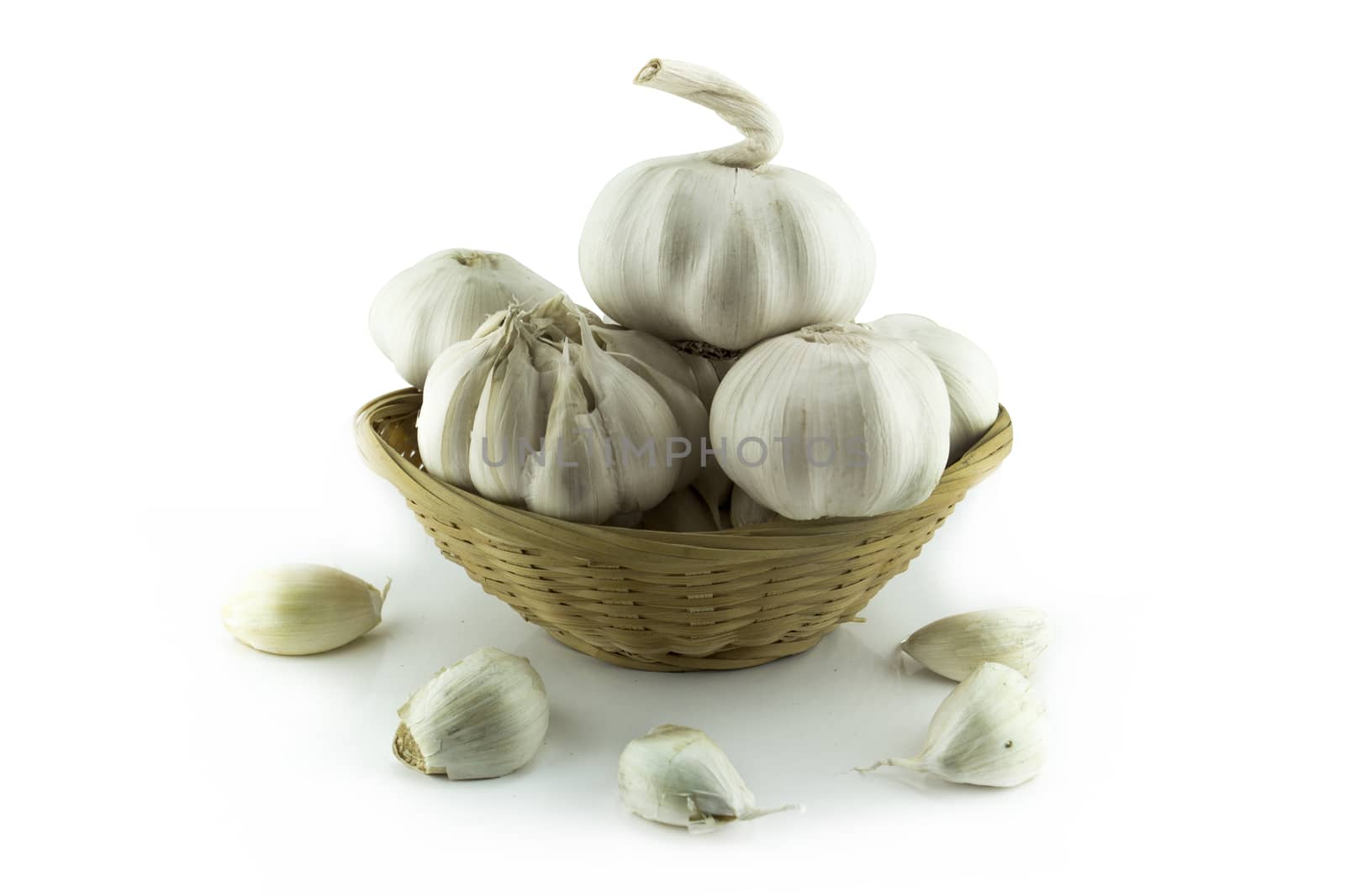 Garlic and garlic bulb in straw dish .