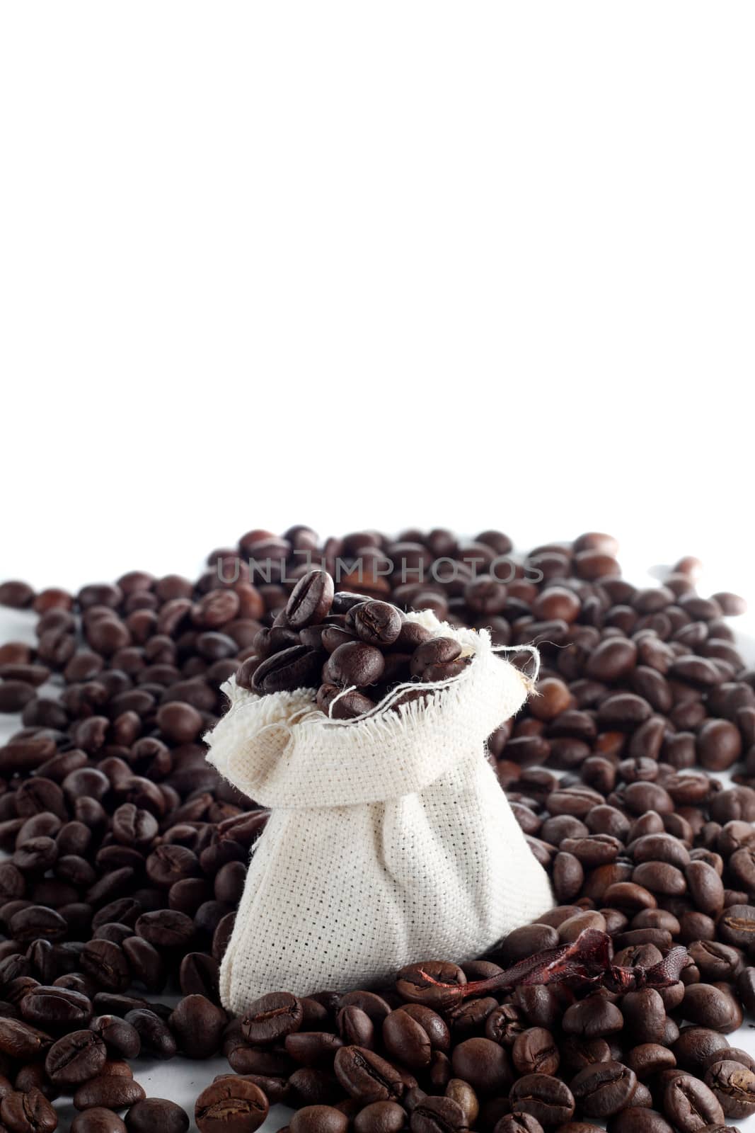 Coffee beans in a sack with a lot of beans around it