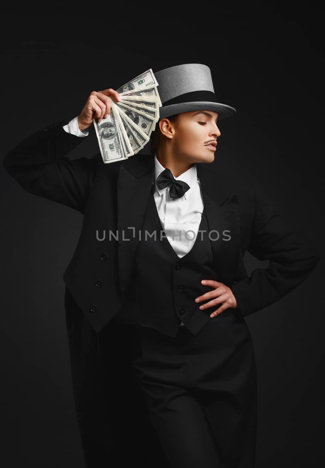The girl in the image of the gangster with dollars in their hands, on the black background