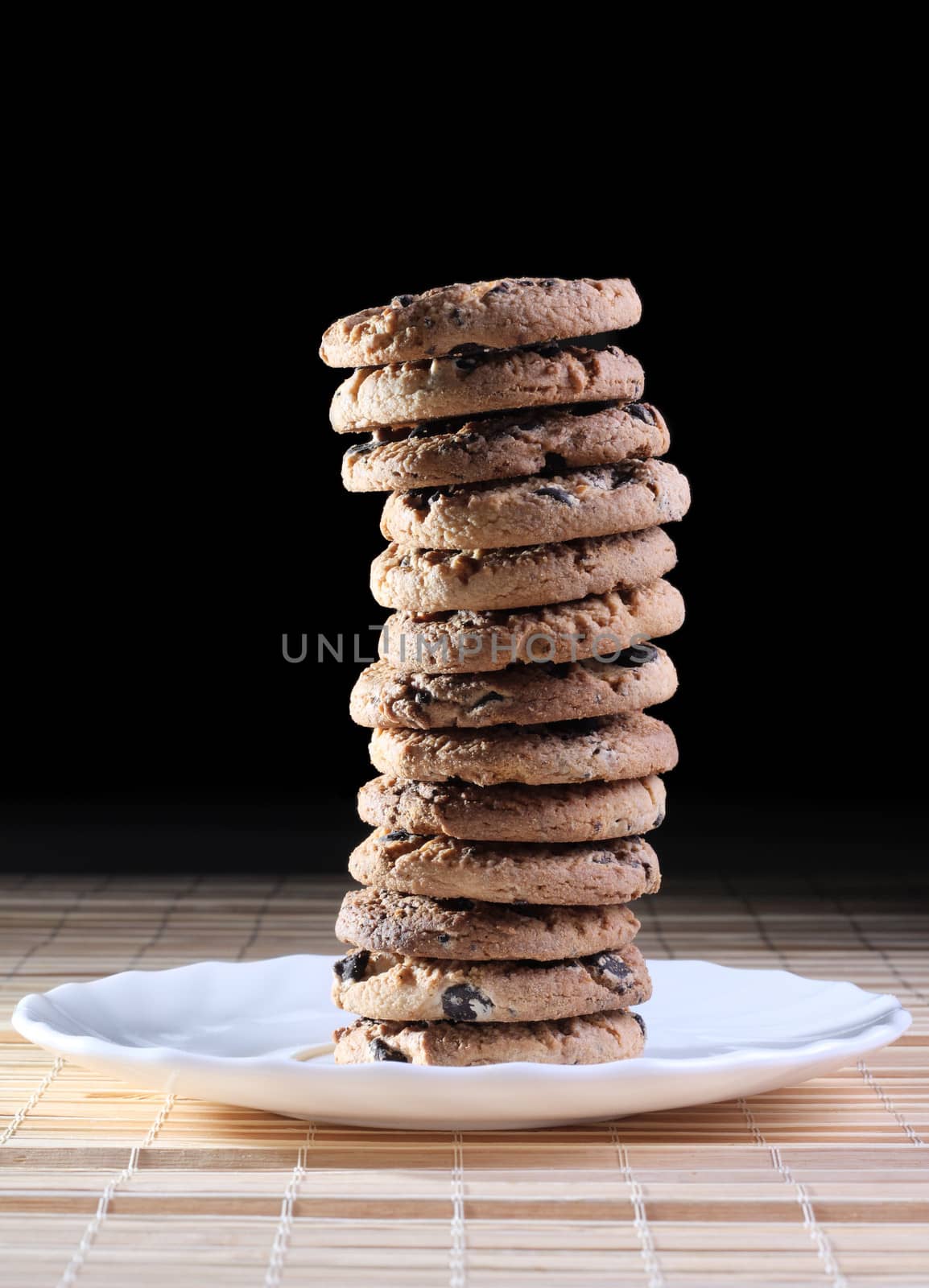 Pile of cookies on the plate at the dark background