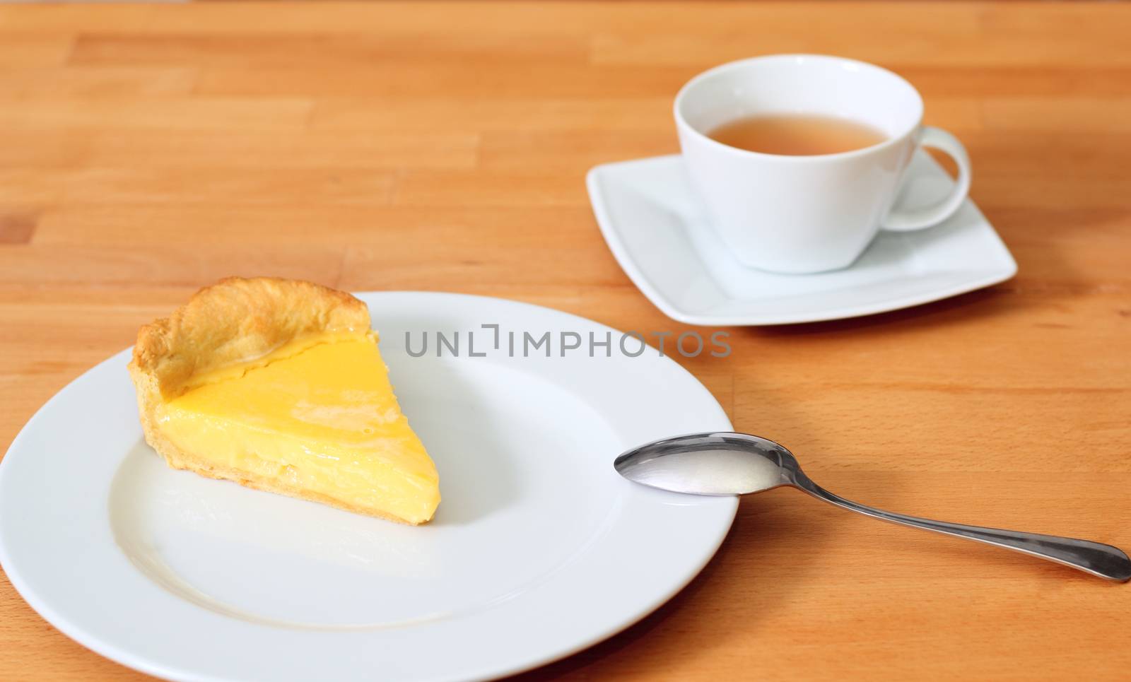 Lemon pie on saucer and tea at the table