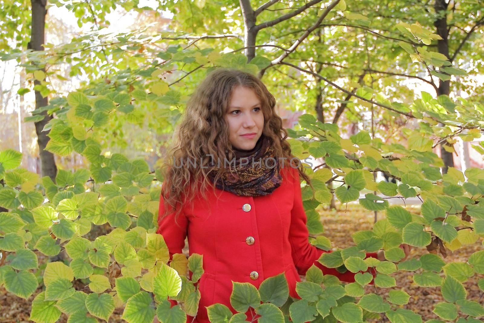 Portrait of thinking young woman in red coat