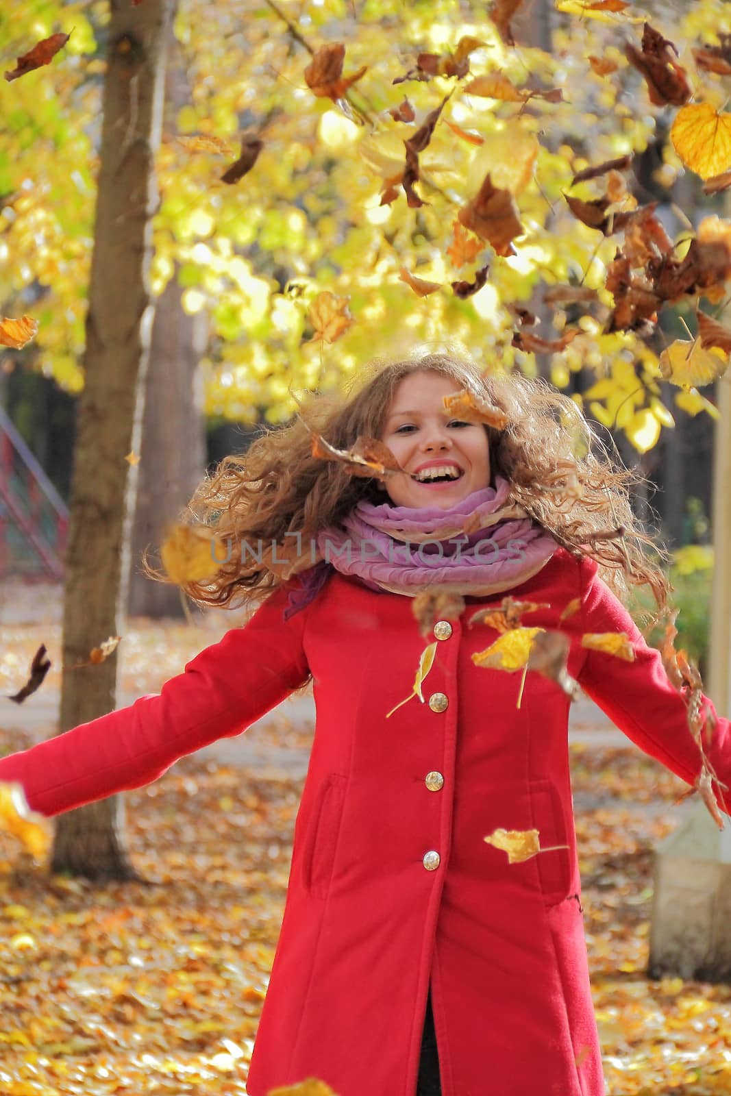 Image of beautiful young woman with autumn leaves