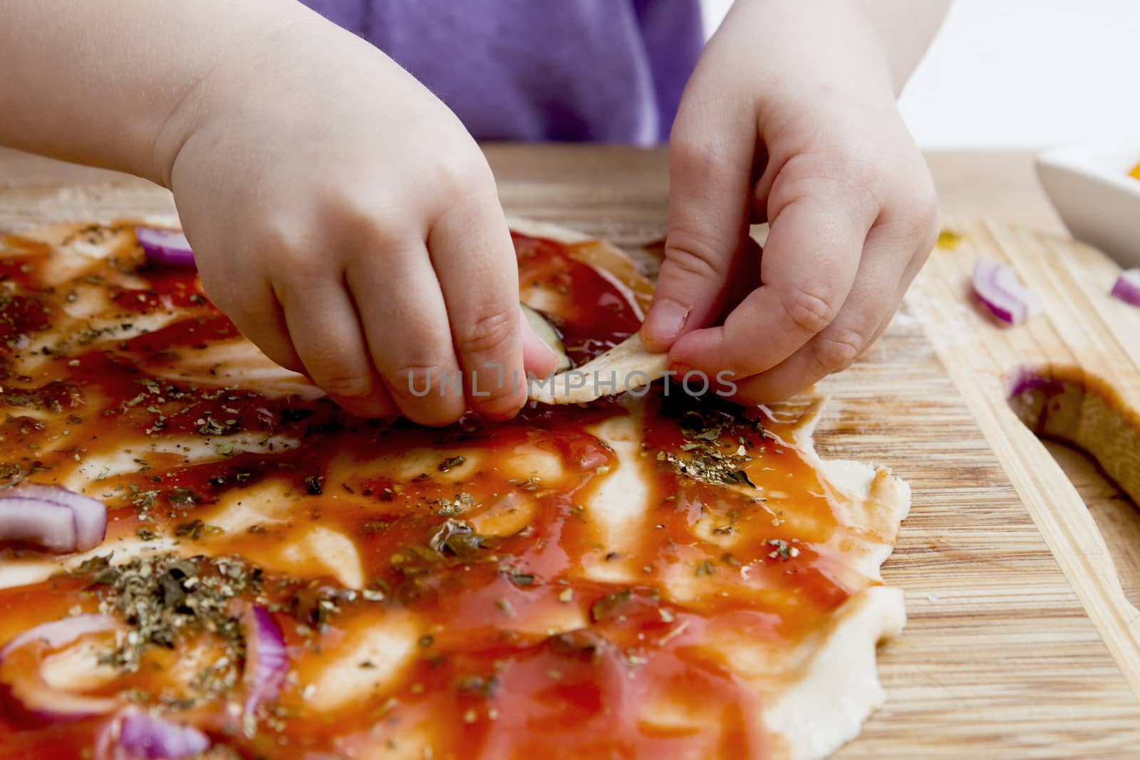 small hands preparing fresh pizza. Studio shot