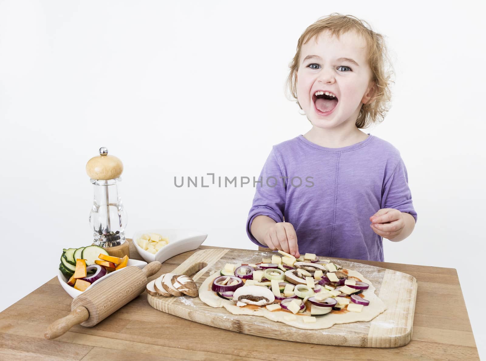 cute child making fresh pizza . studio shot isolated on grey background