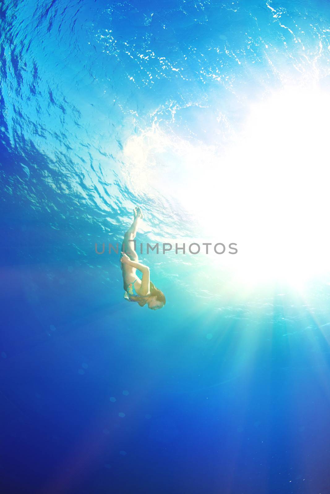 athletic girl diving under the sea