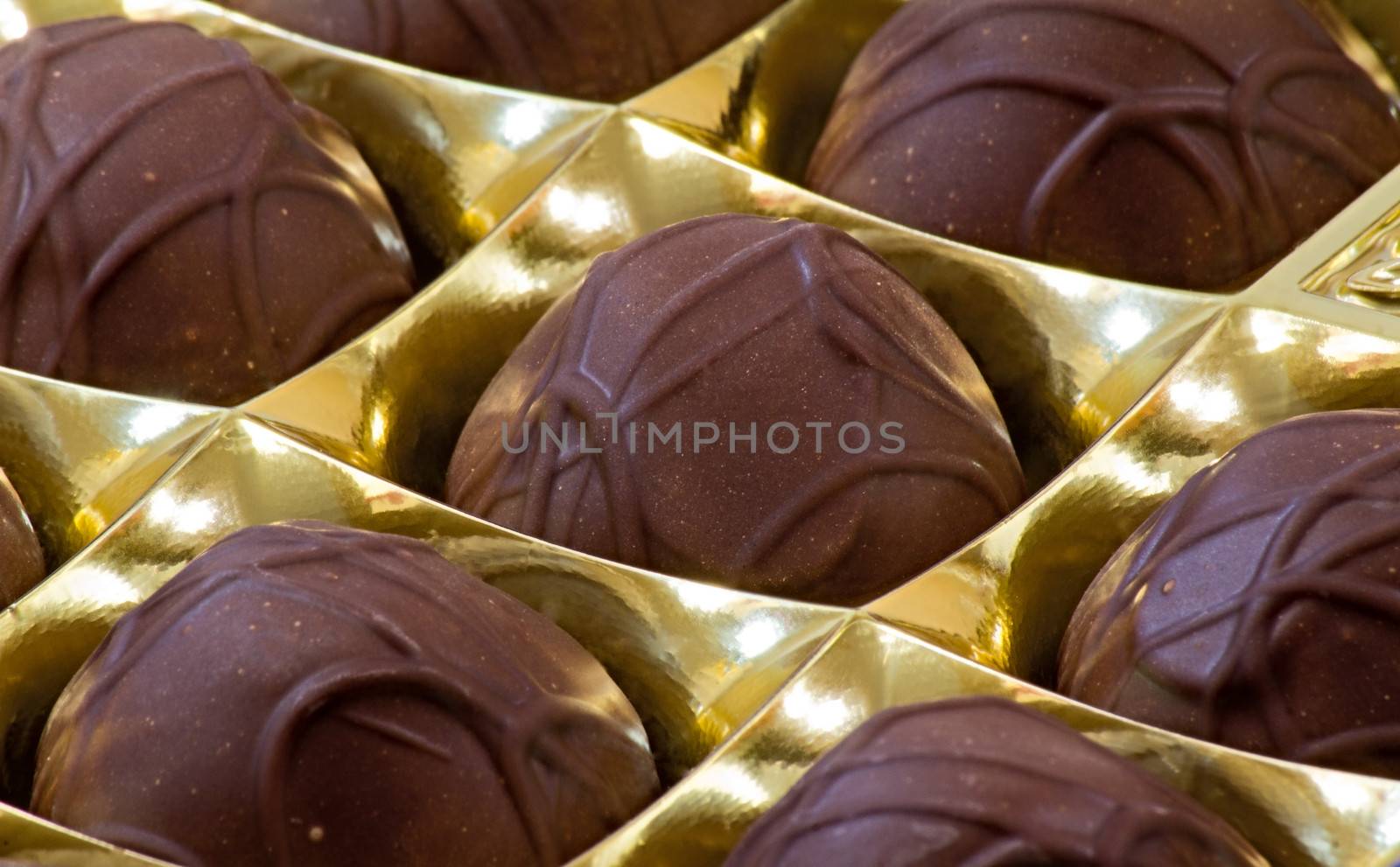 Fragment of the packaging with large beautiful chocolates. Photographed close up.
