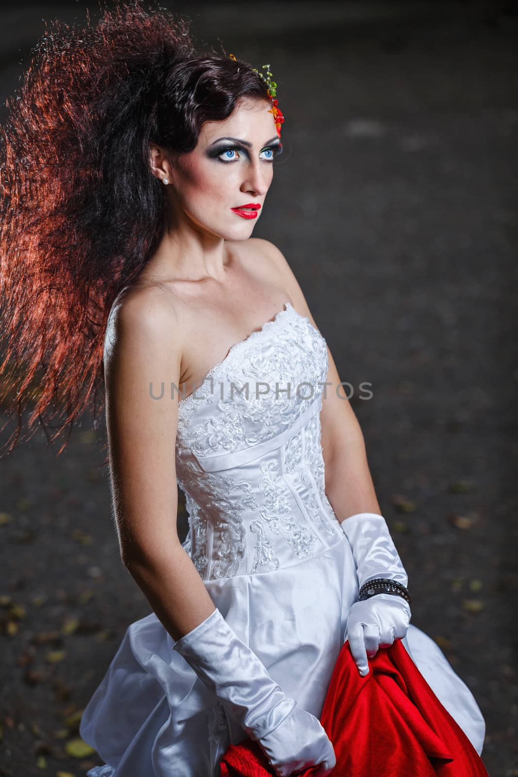 Attractive bride in a wedding dress with bright makeup, red shawl