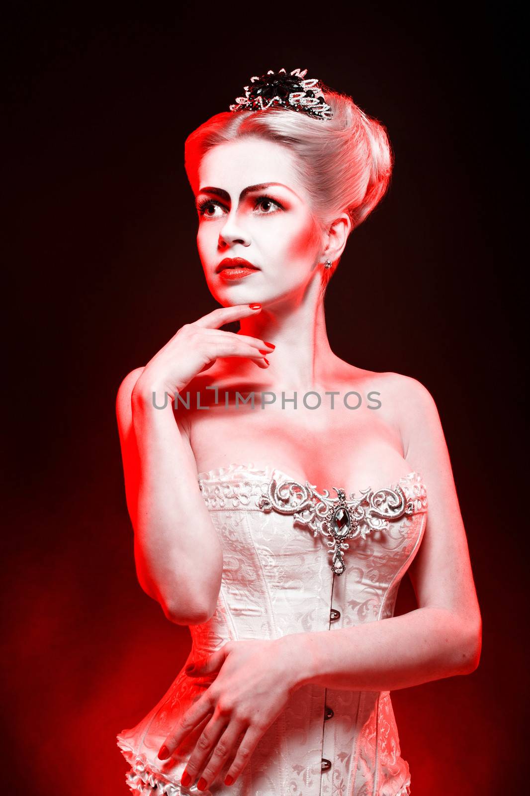 Red Queen with a crown and a corset, with make-up in studio shot