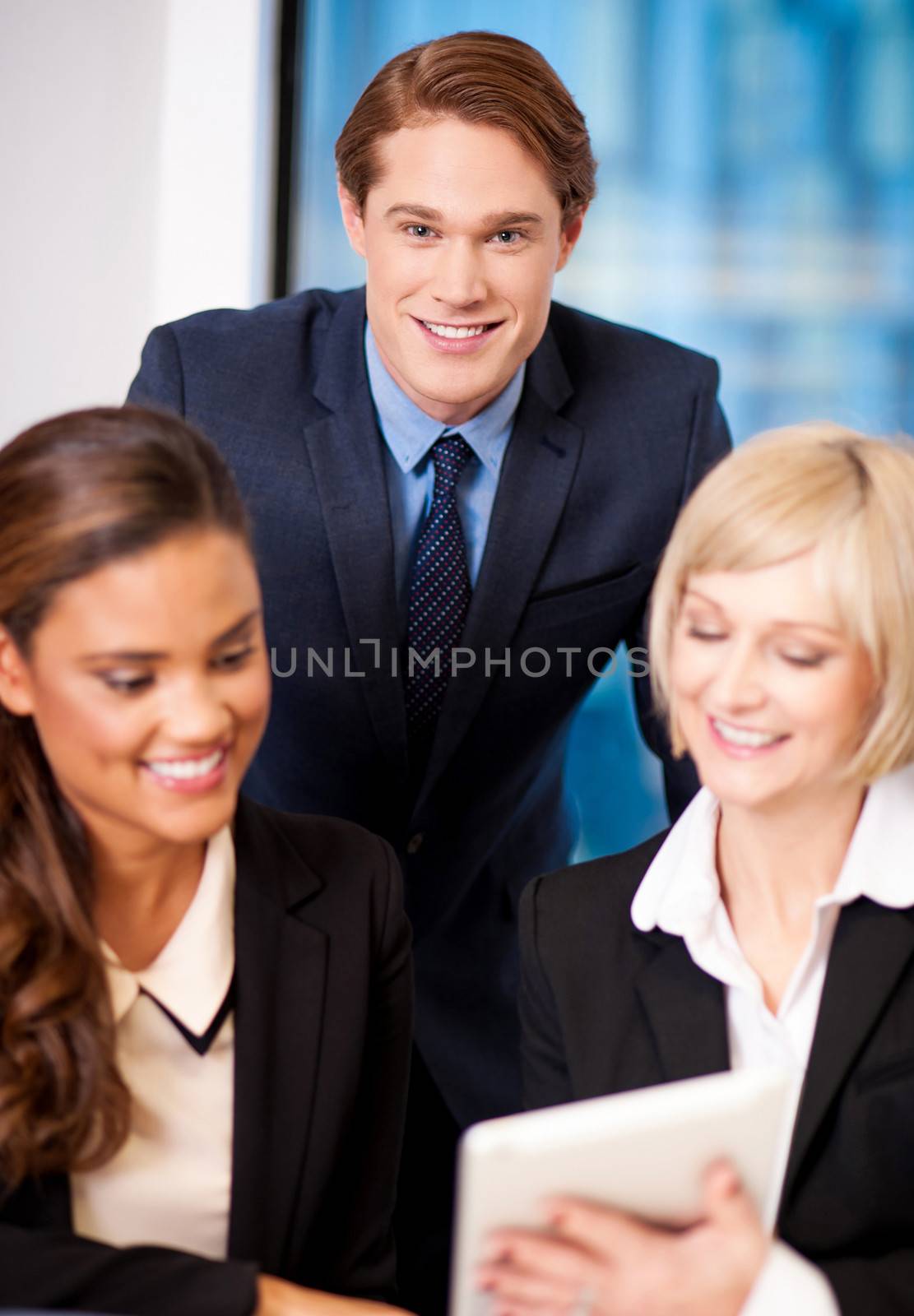 Happy business team at the office by stockyimages