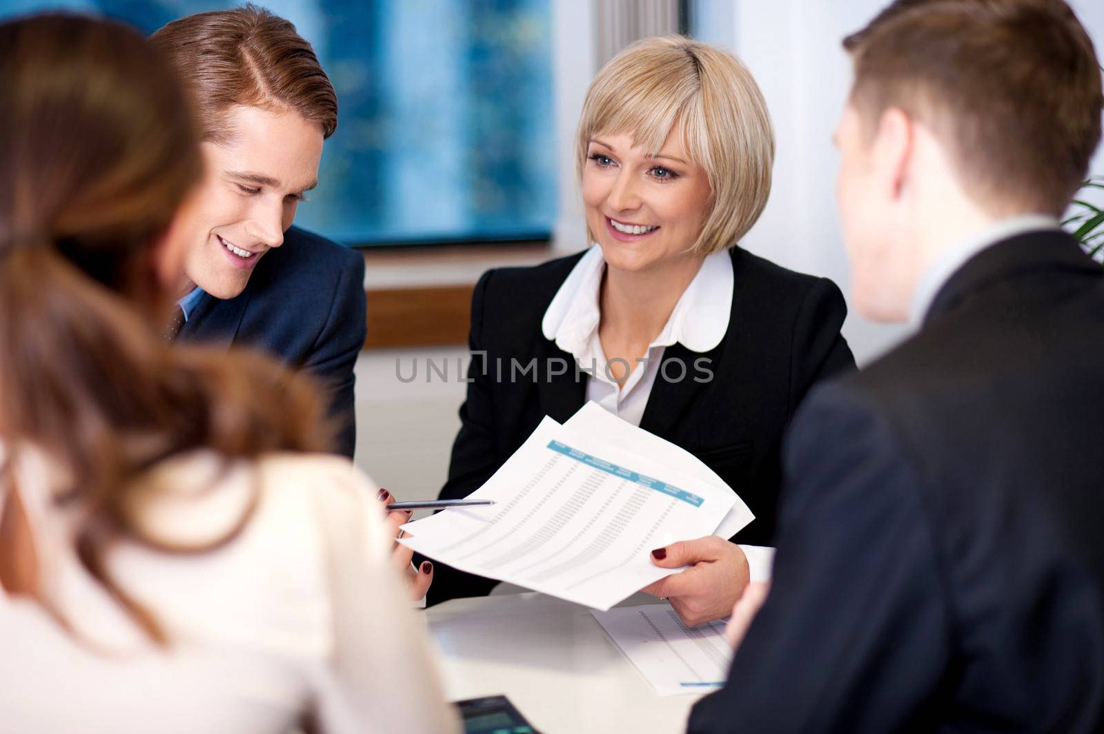 Company discussion going on in a meeting hall by stockyimages