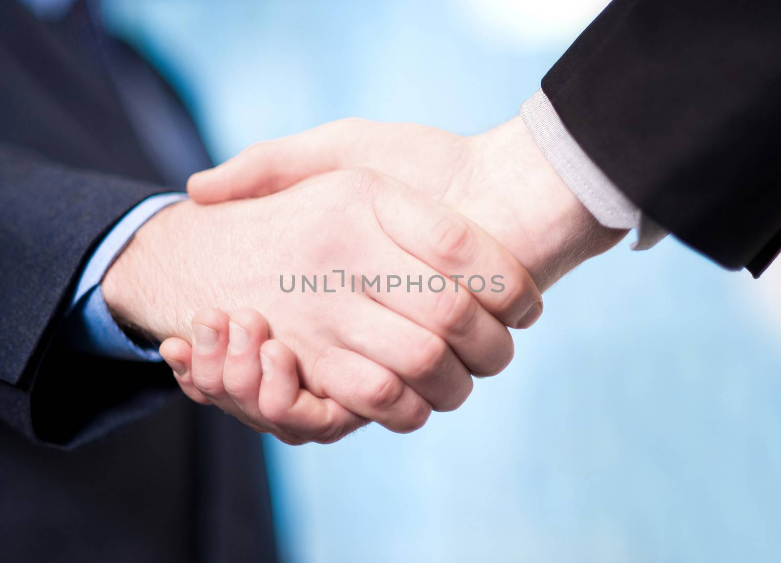 Successful businessmen shaking hands by stockyimages