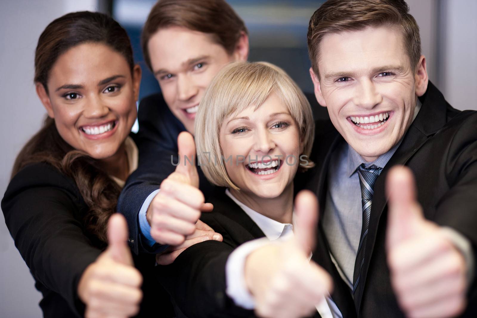 Corporate team gesturing thumbs up by stockyimages