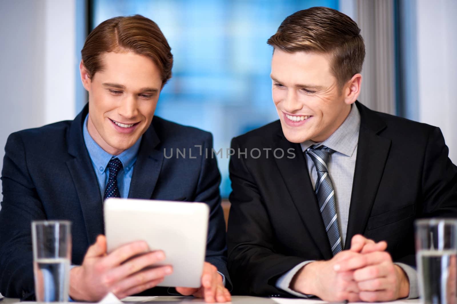 Businessmen browsing on tablet device by stockyimages