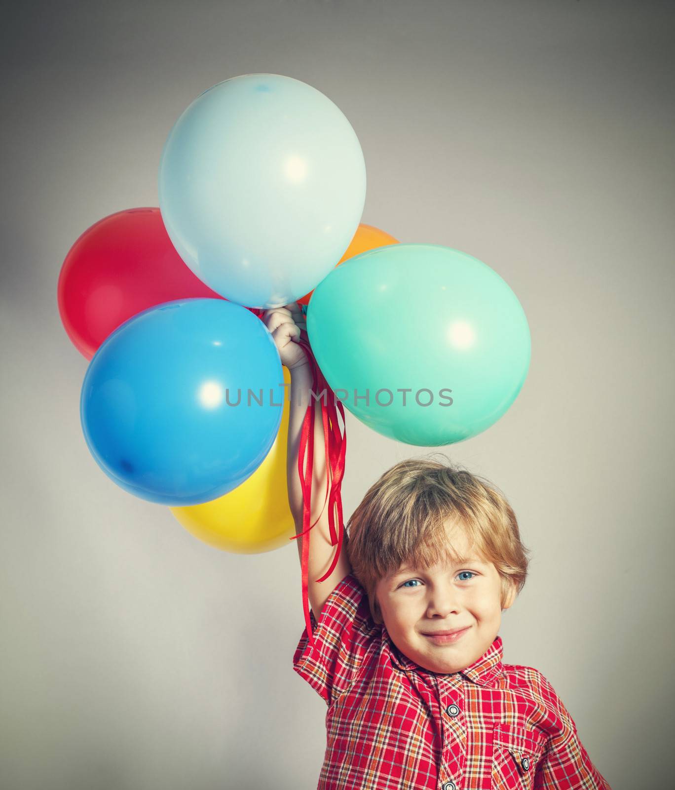 Boy holding the bunch of balloons by anelina