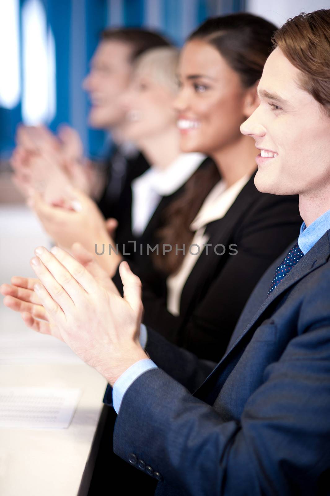 Team of four corporates applauding by stockyimages