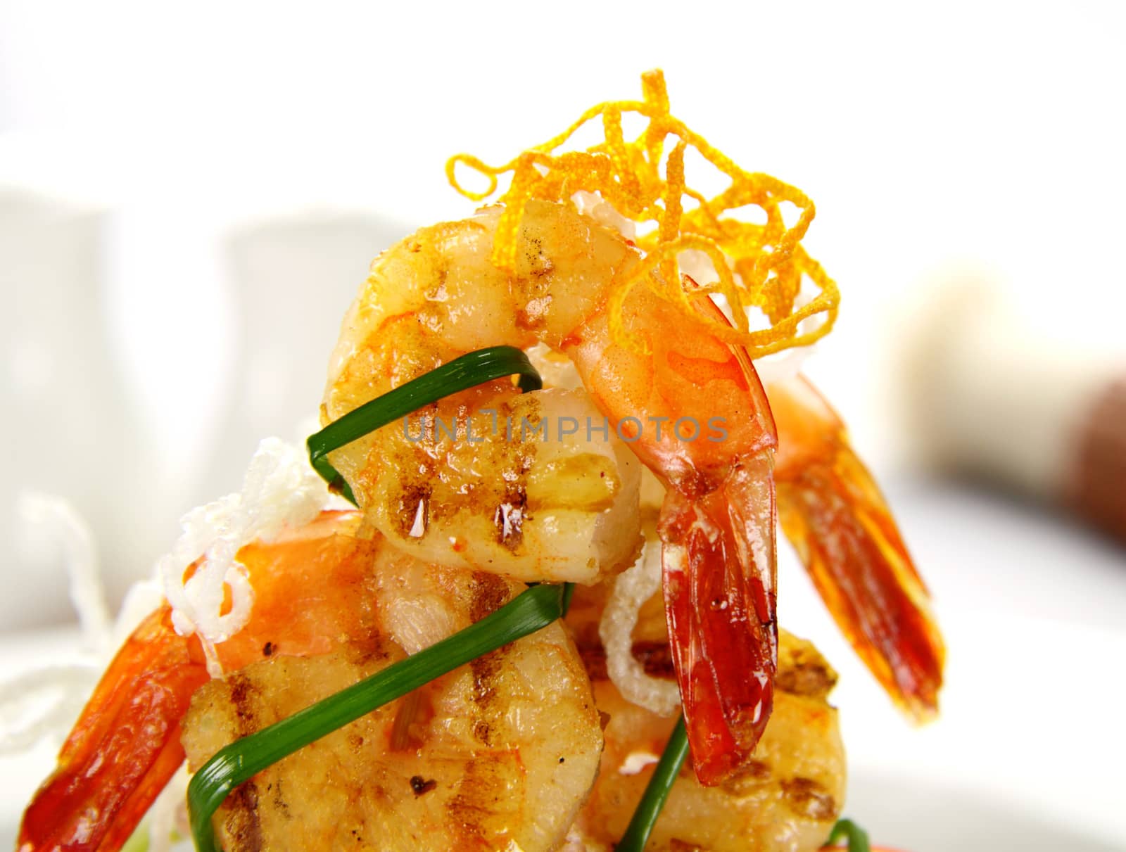 Stack of chargrilled shrimps tied up with chives.