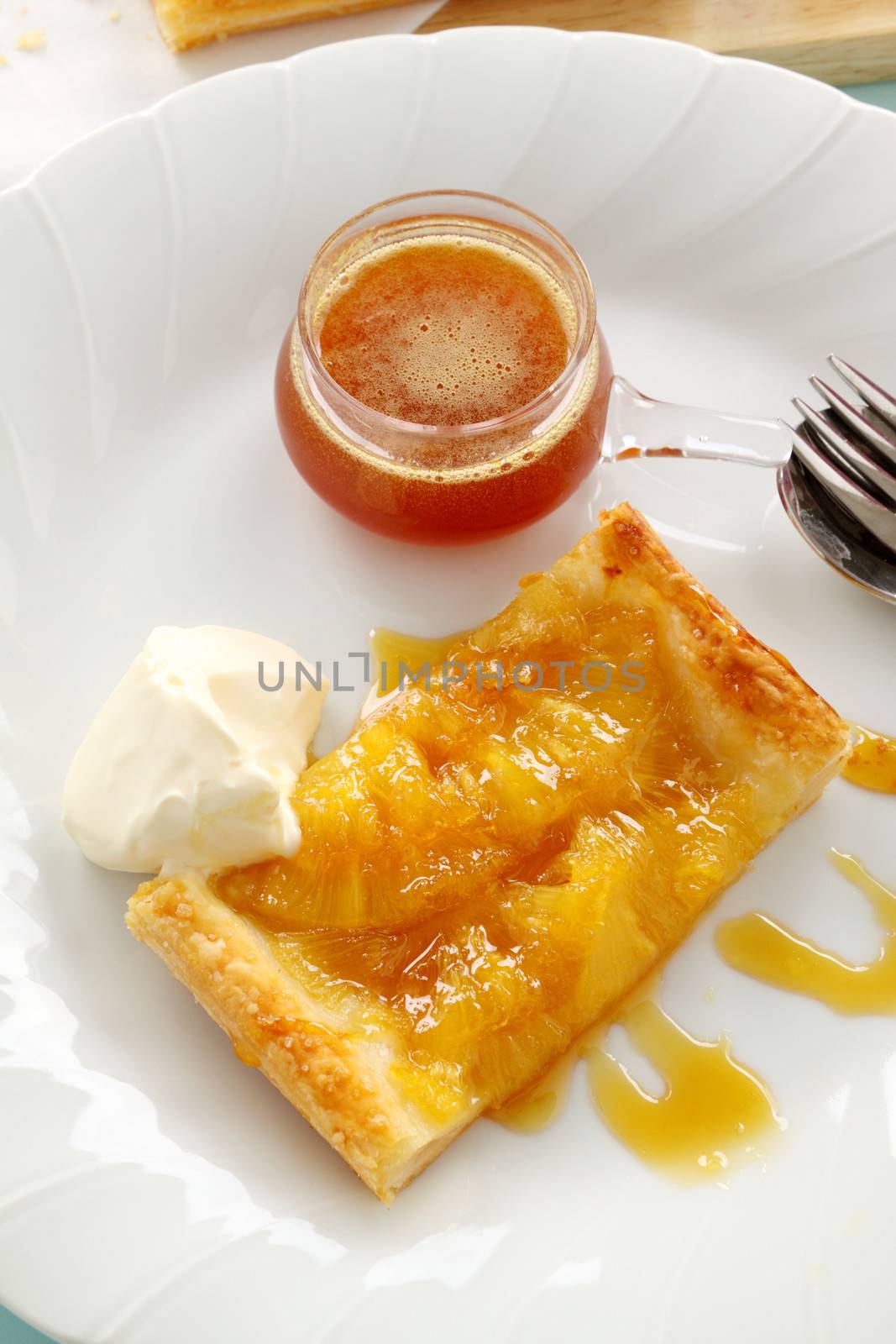 Delicious spiced pineapple galette served with cream and pineapple syrup.