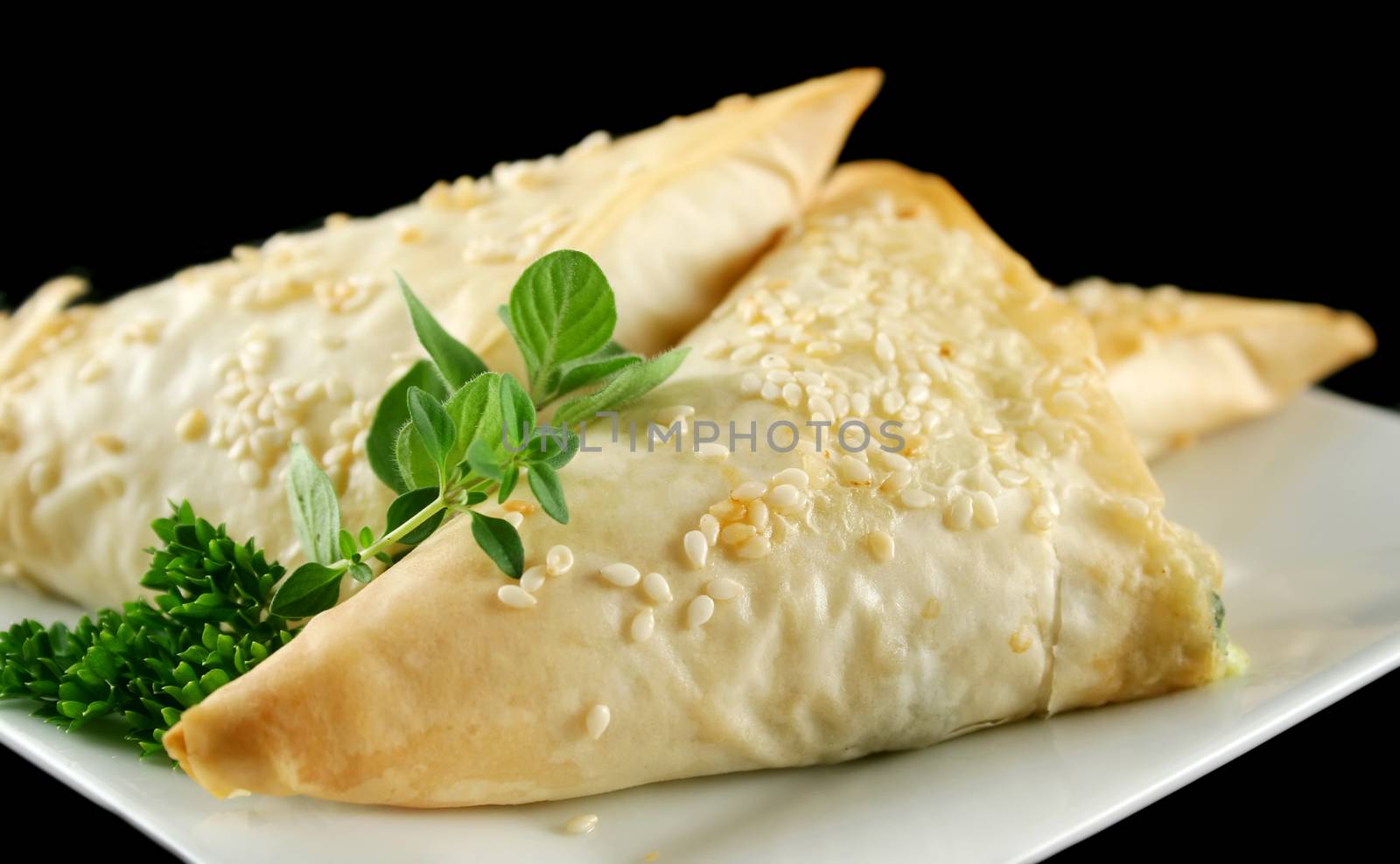 Spinach and feta cheese triangles with garnish.