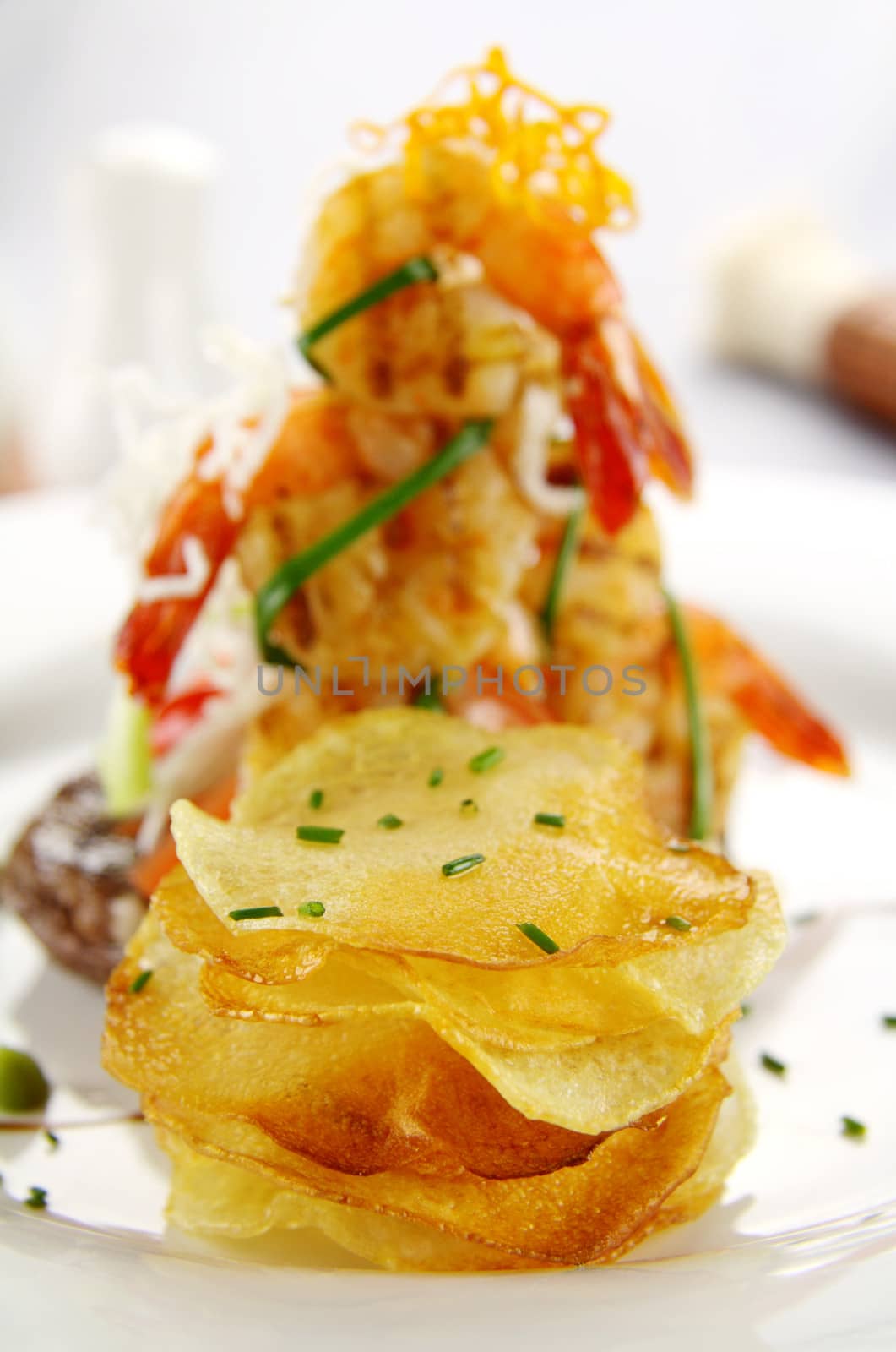 Stack of crisp potato chips with a shrimp stack in the background.