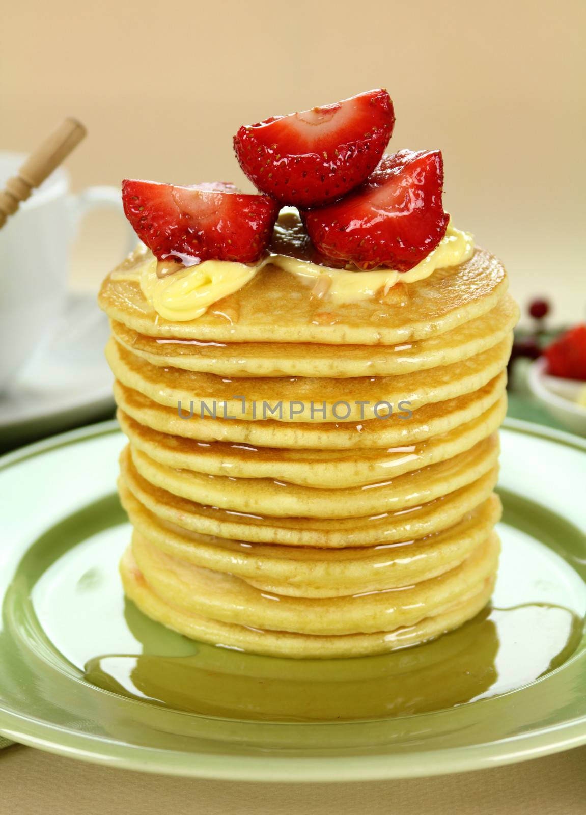 Delicious strawberry pancake stack stack dripping with honey with cream.