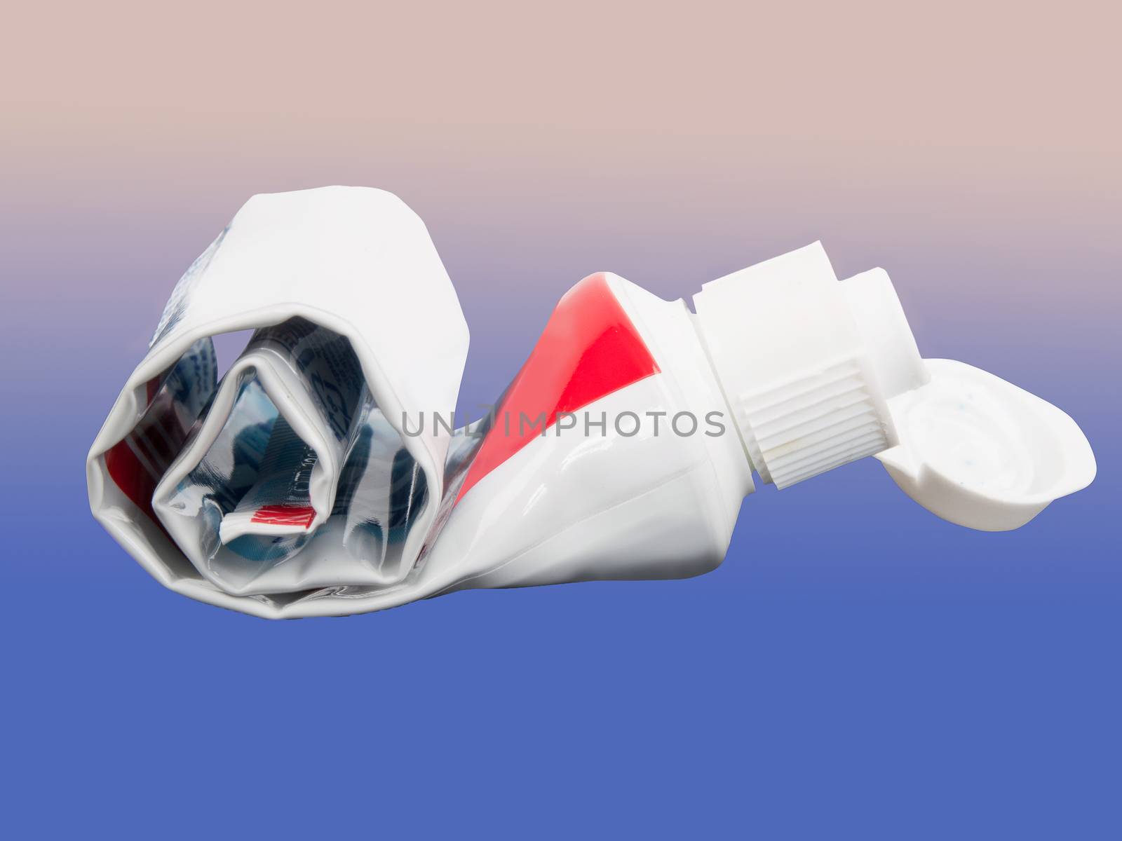 empty rolled toothpaste isolated on abstract background