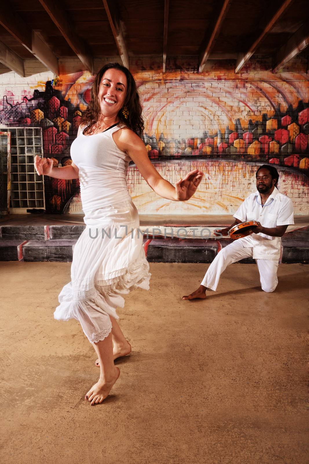 Brazillian dancer and pandeiro drummer performing indoors