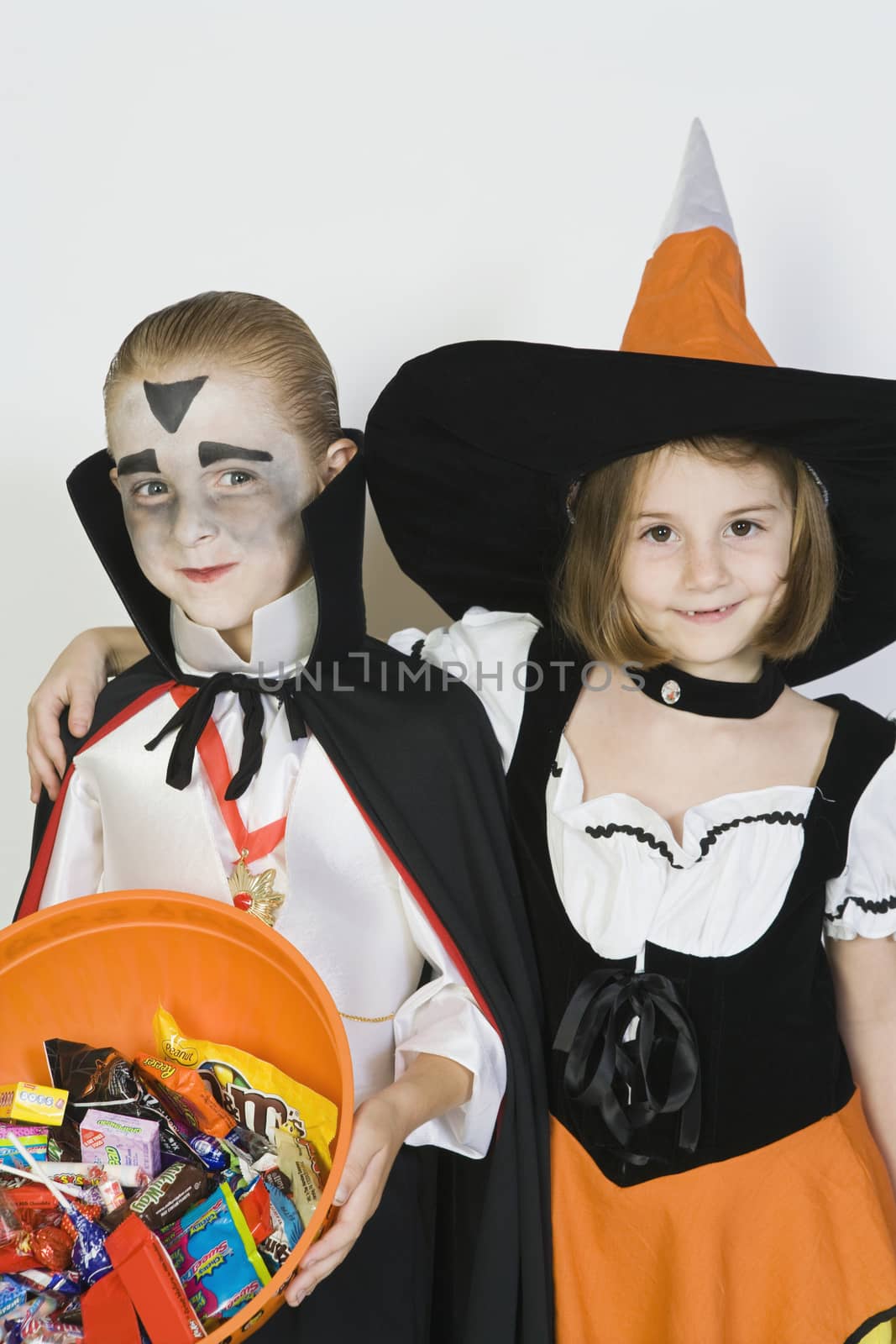 Portrait of girl embracing boy (7-9) wearing Halloween costumes by moodboard