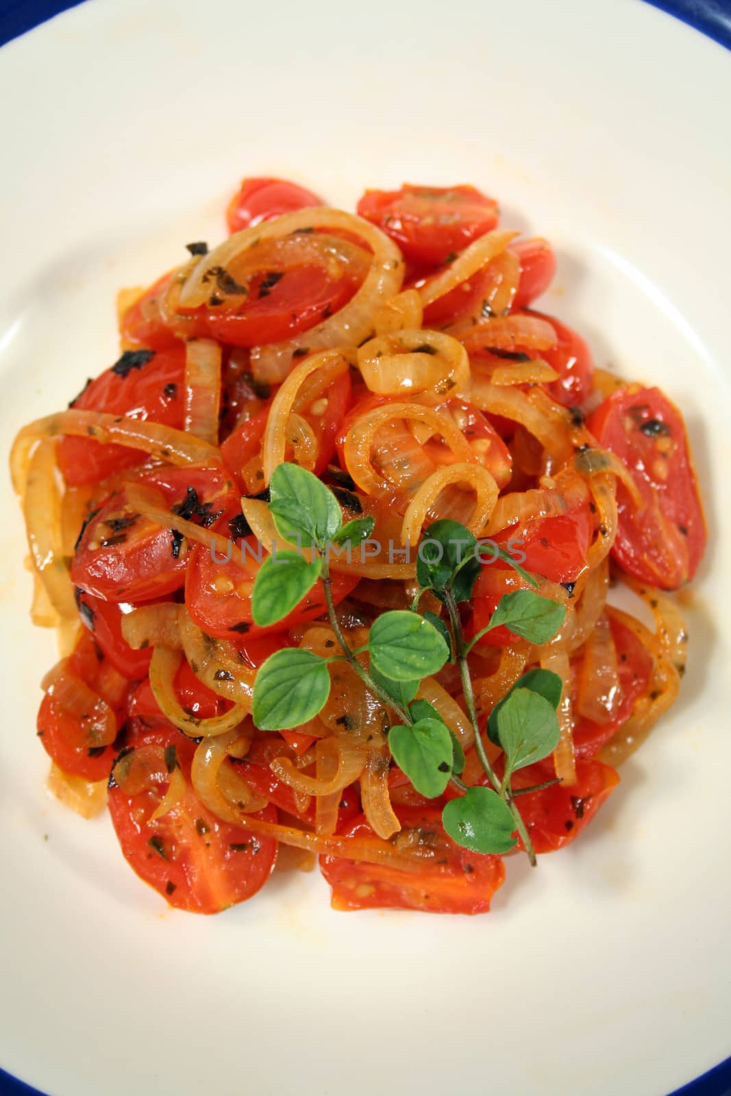 Warm salad consisting of cherry tomatoes and caramelized onion with oregano. 