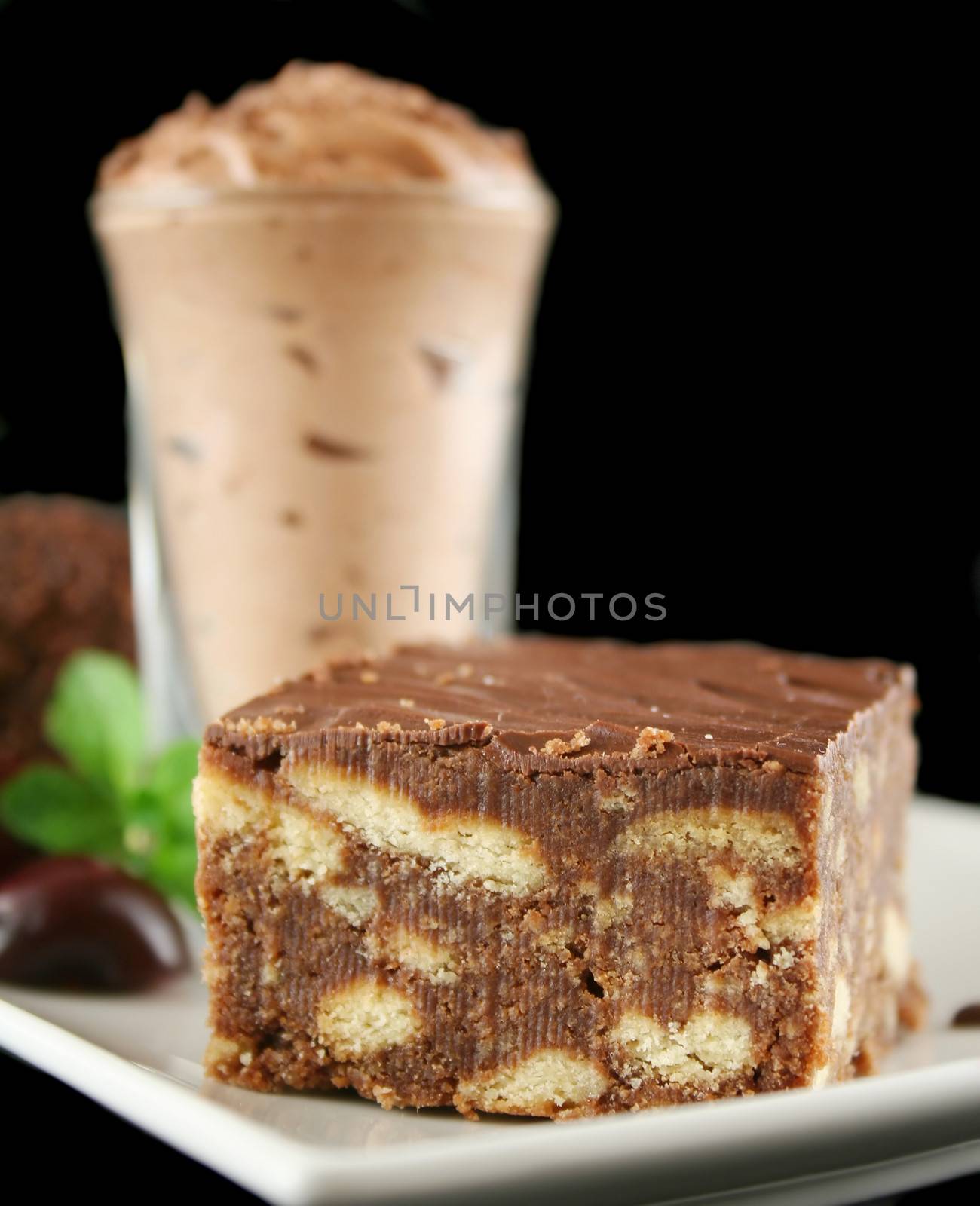Chocolate slice with chocolate mousse in the background.