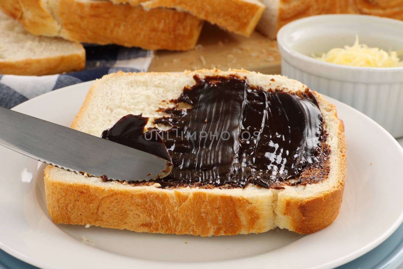 Spreading the iconic Australian spread vegemite on to a slice of fresh bread.