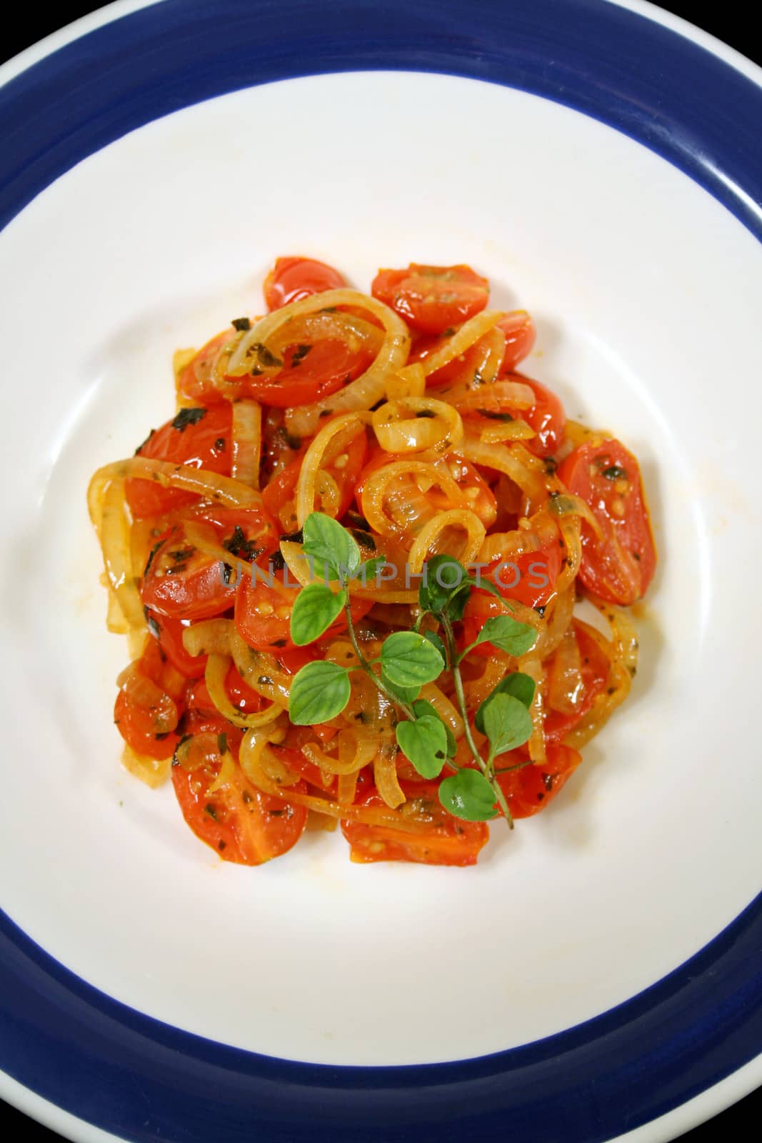 Warm salad consisting of cherry tomatoes and caramelized onion with oregano. 
