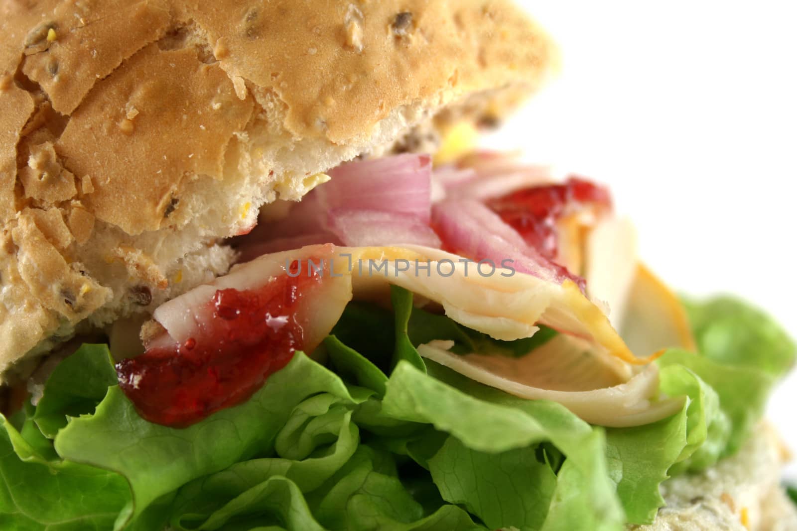 Turkey and lettuce with red onions and cranberry sauce on a wholemeal roll.