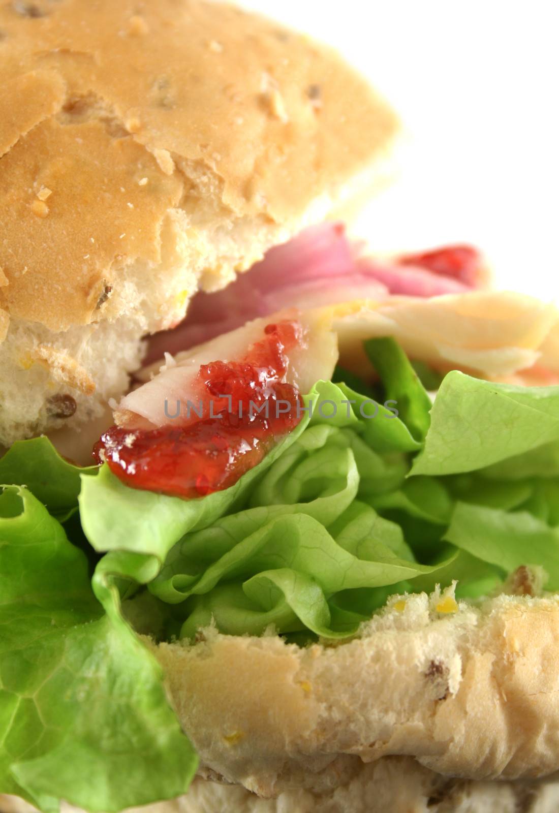 Turkey and lettuce with red onions and cranberry sauce on a wholemeal roll.