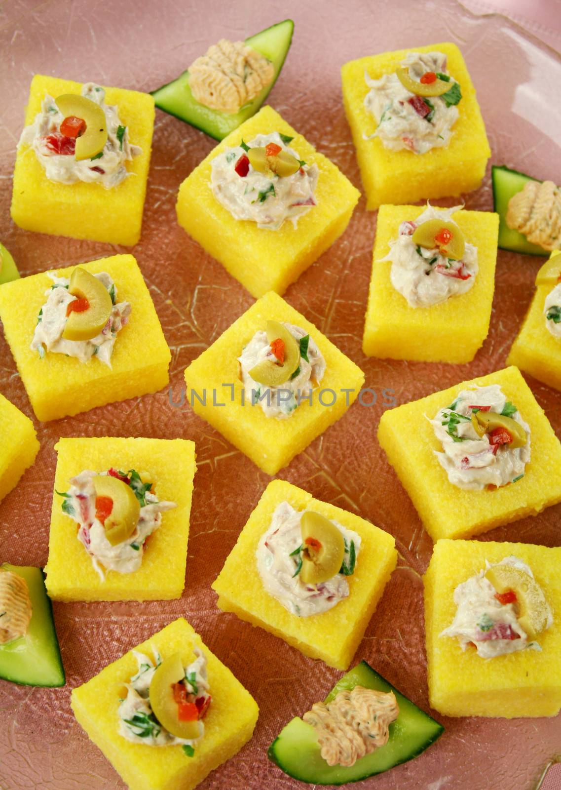 Tuna filled polenta squares with cream cheese, olives and parsley.