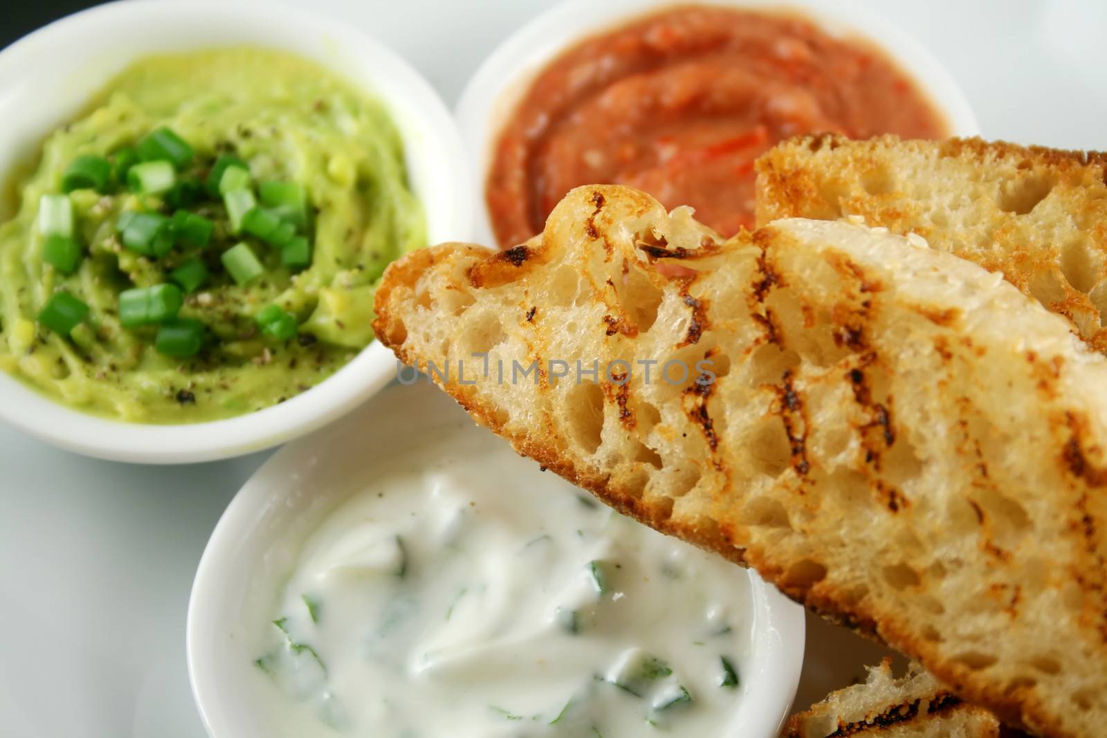 Delicious and colorful trio of dips with grilled Turkish bread.