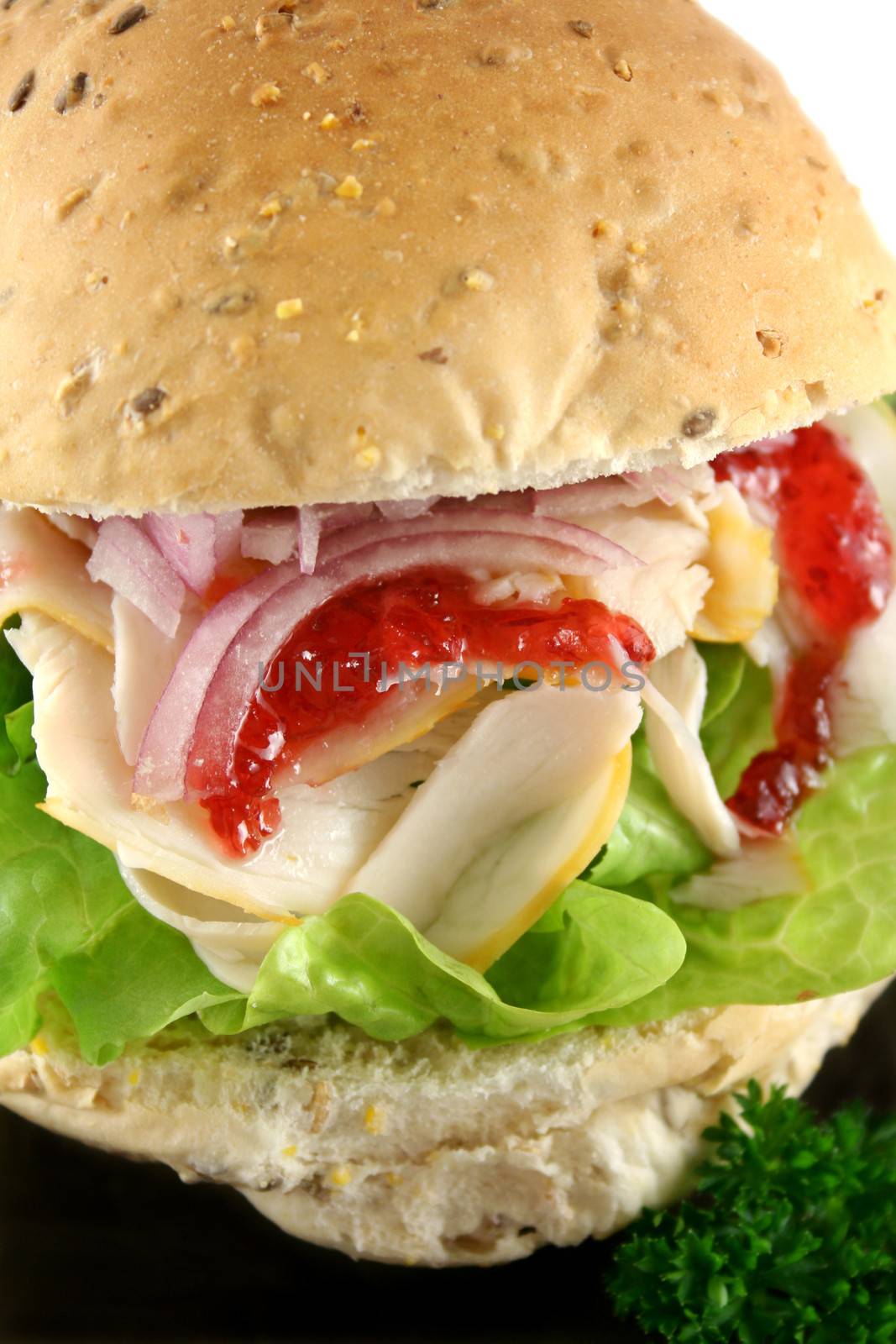 Turkey and lettuce with red onions and cranberry sauce on a wholemeal roll.