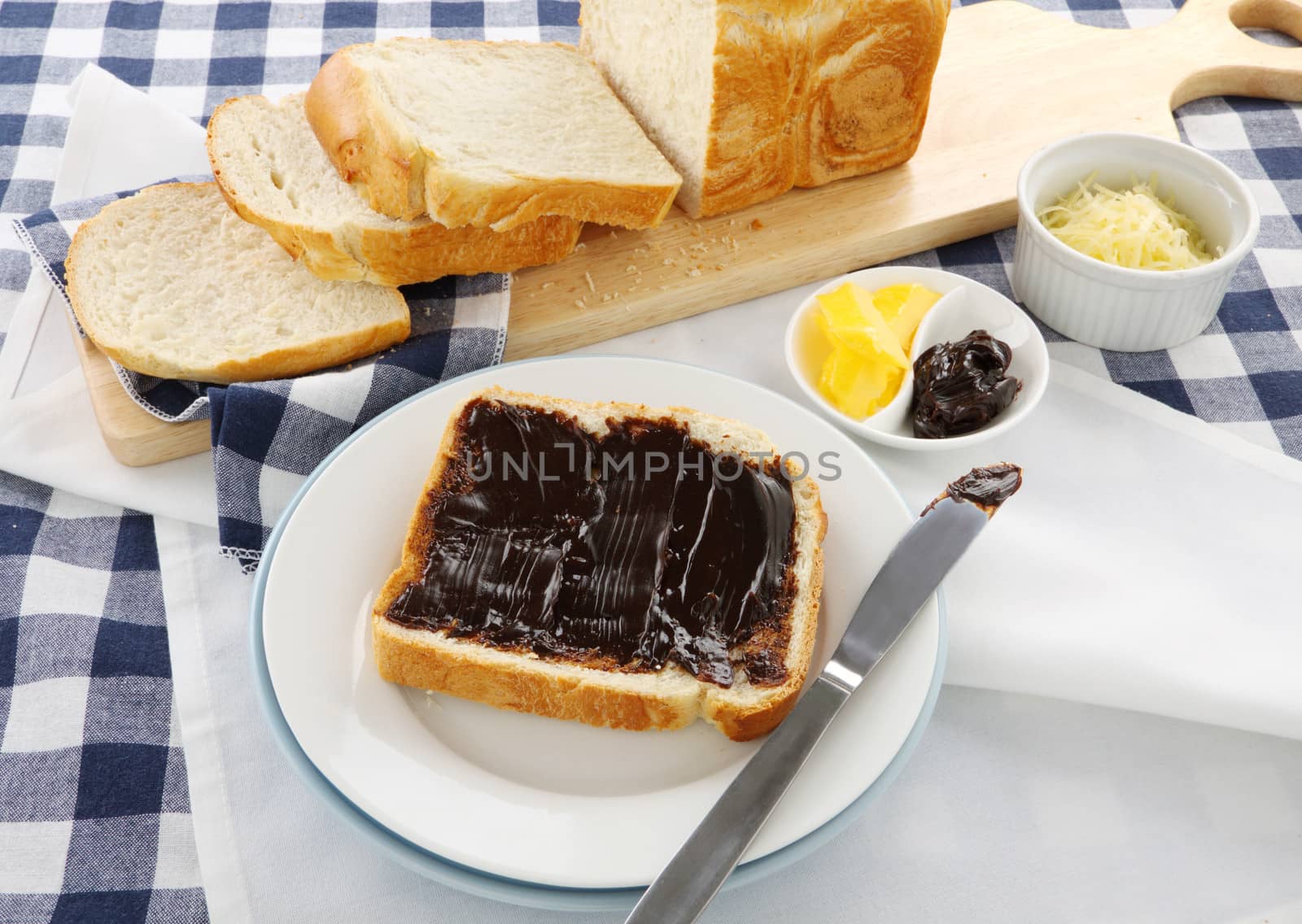 The iconic Australian spread vegemite on to a slice of fresh bread.