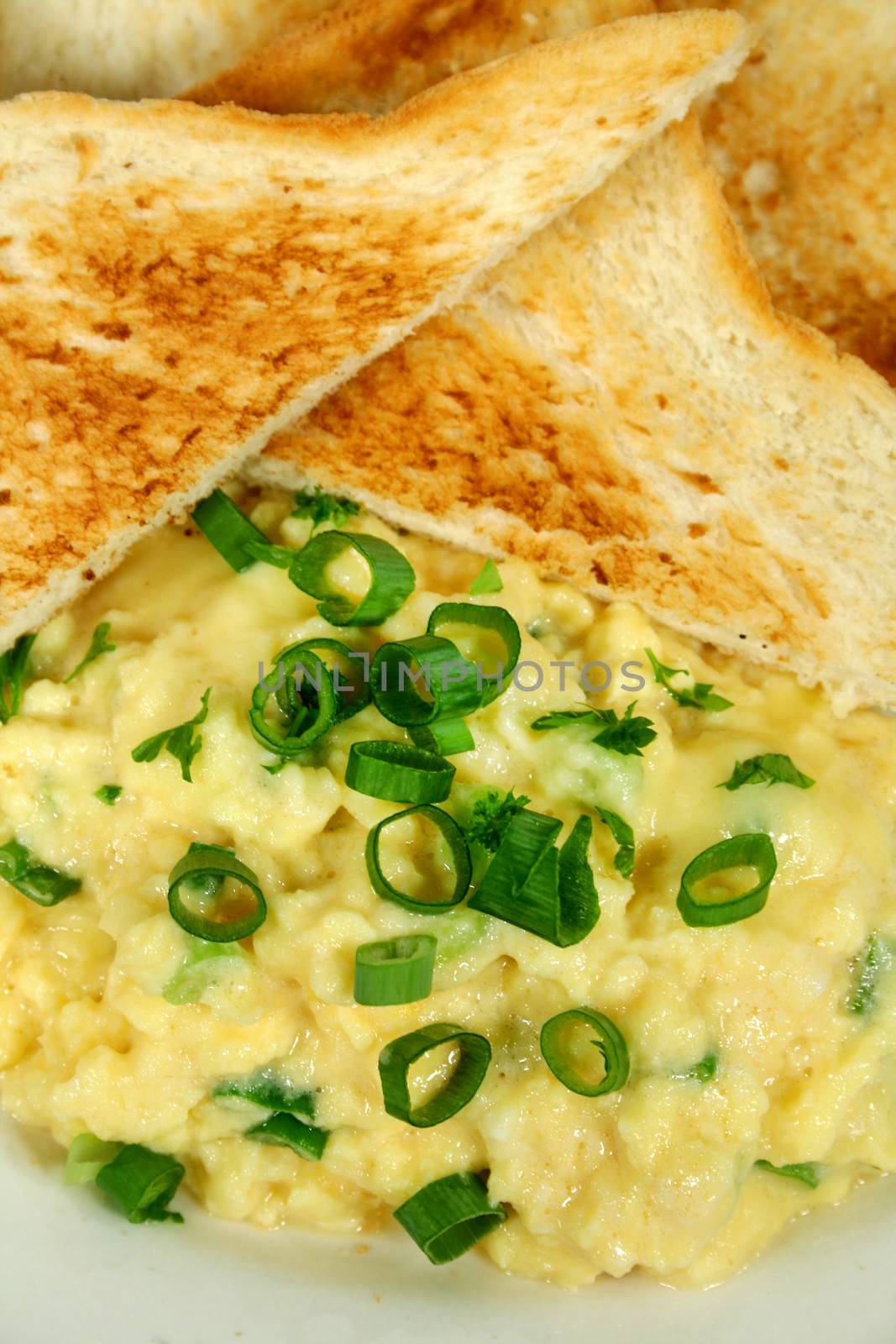 Great breakfast of creamy scrambled eggs with toast and diced shallots.